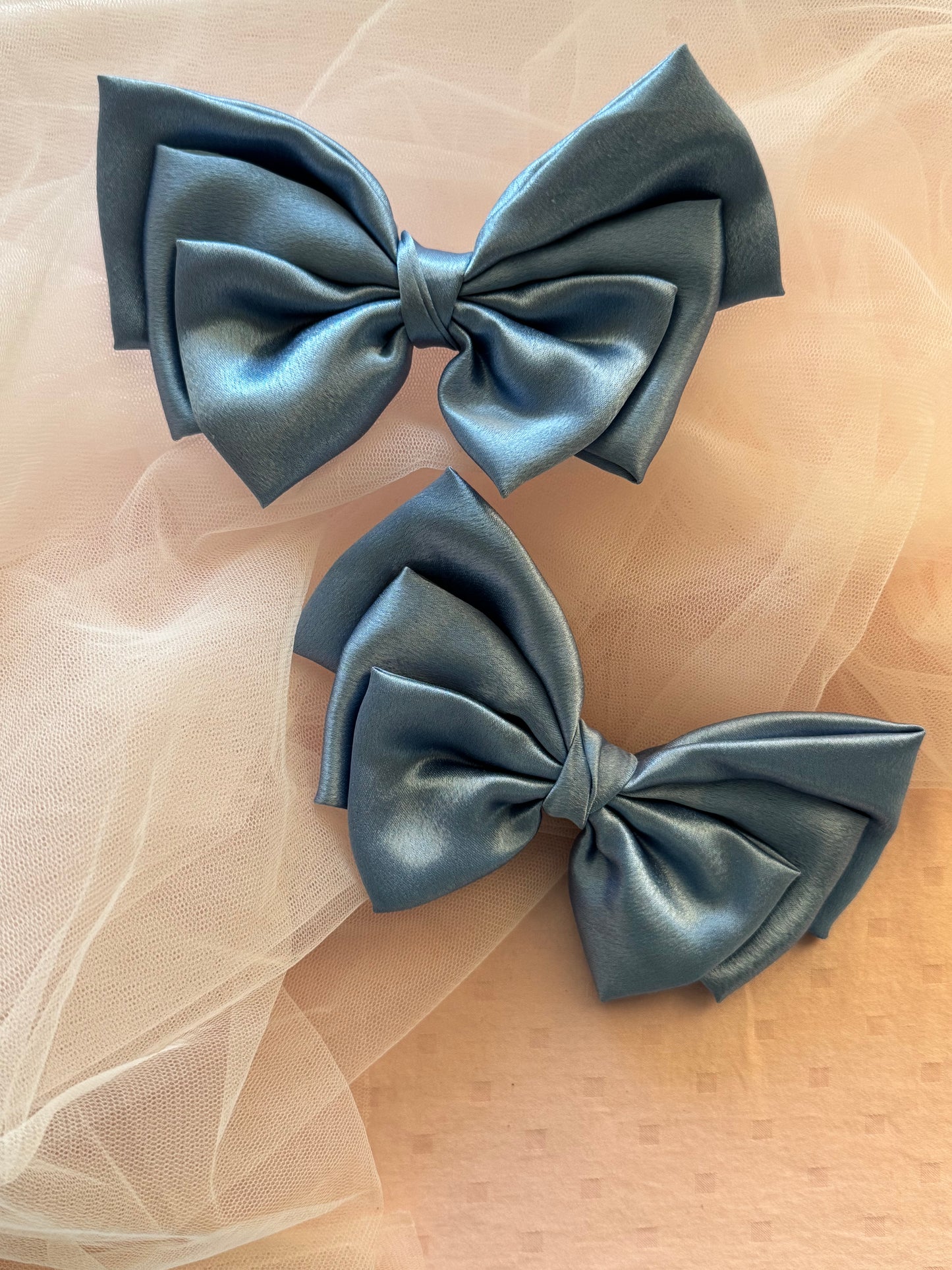Two Ocean Drop Hair Bows - Front view of large metallic ice blue satin hair bow clips, perfect for adding a bold yet elegant statement to any hairstyle.