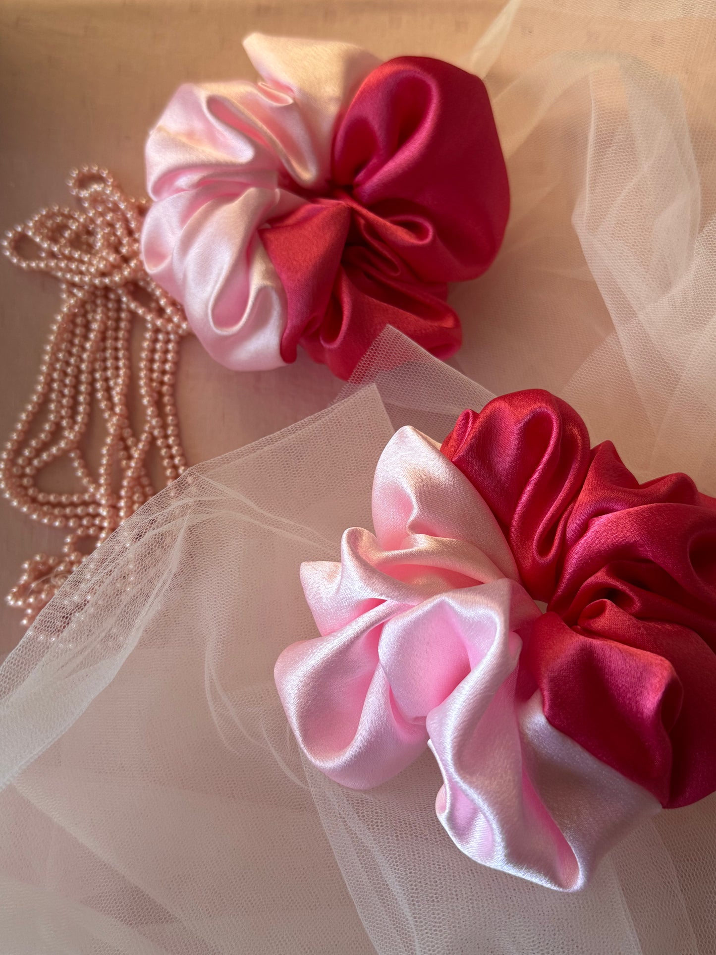 Two Scrunchies outlining the beautiful light and dark pink shades displayed with both colors with Props