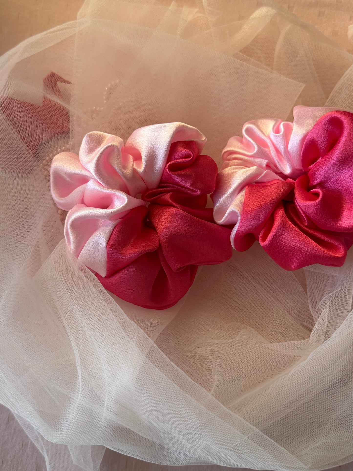 Two Scrunchies outlining the beautiful light and dark pink shades displayed with both colors Vertically kept aligned parallely