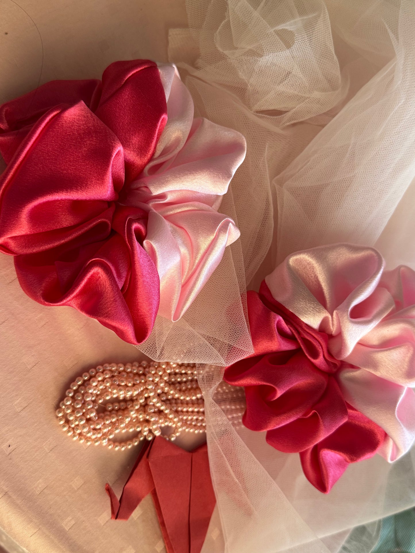 Two Scrunchies outlining the beautiful light and dark pink shades displayed with both colors vertically kept aligned parallely with props