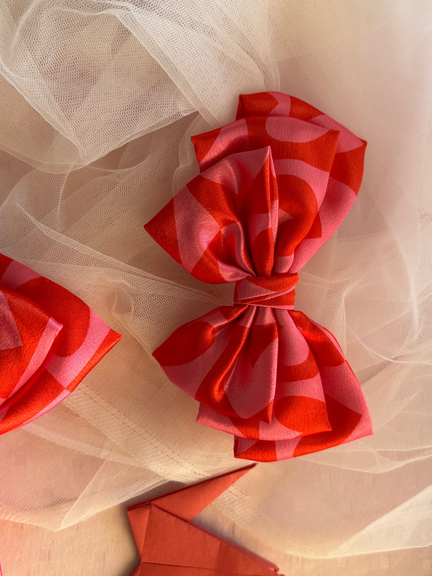 Love Struck Hair Bow Clip - Front view of a large pink satin hair bow with heart prints, radiating love and playfulness for a charming look