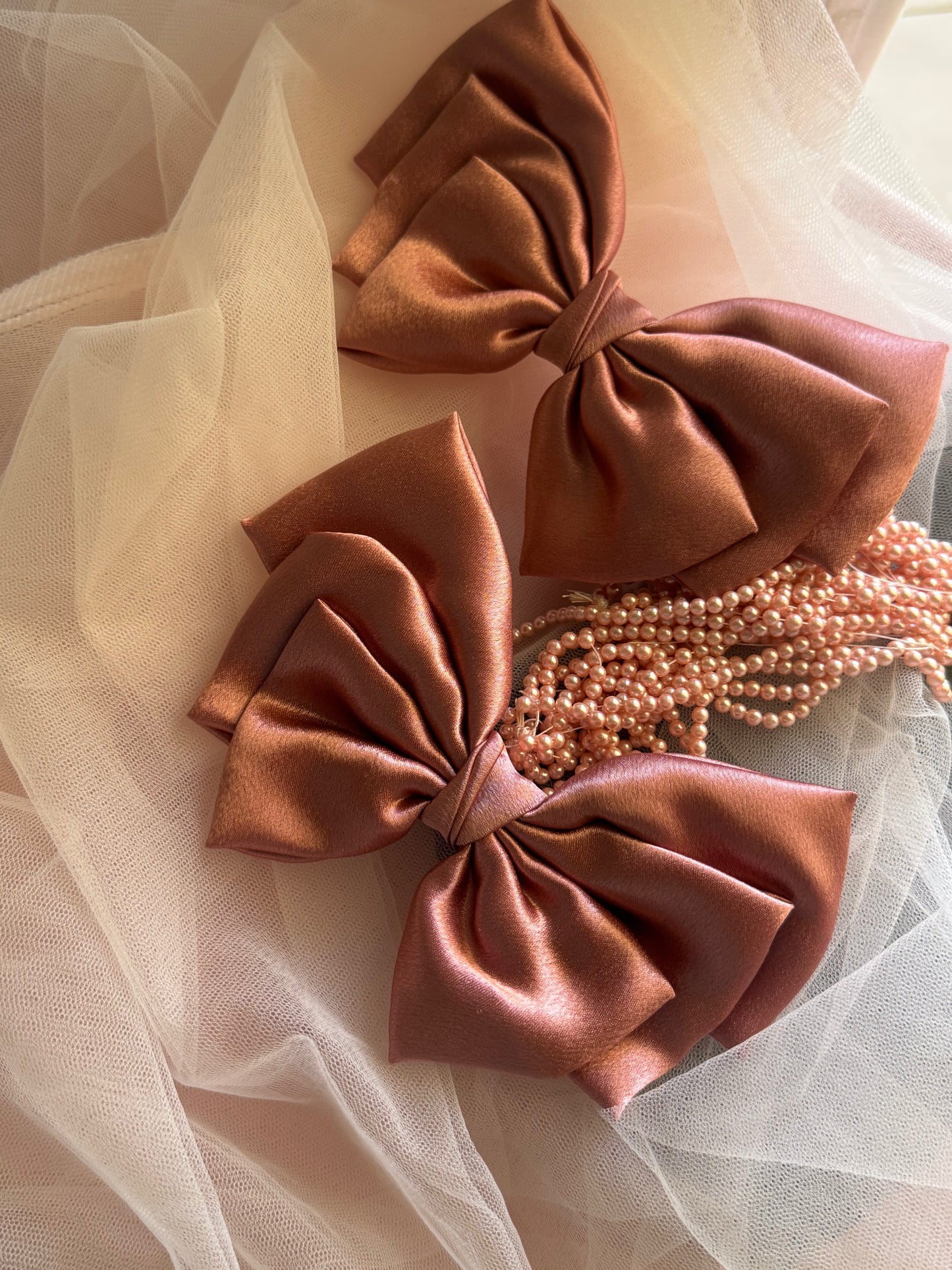 Two Satin Hair bows with Clip Front Size, beautiful metallic Peach Color, with Props ket vertically at an angle