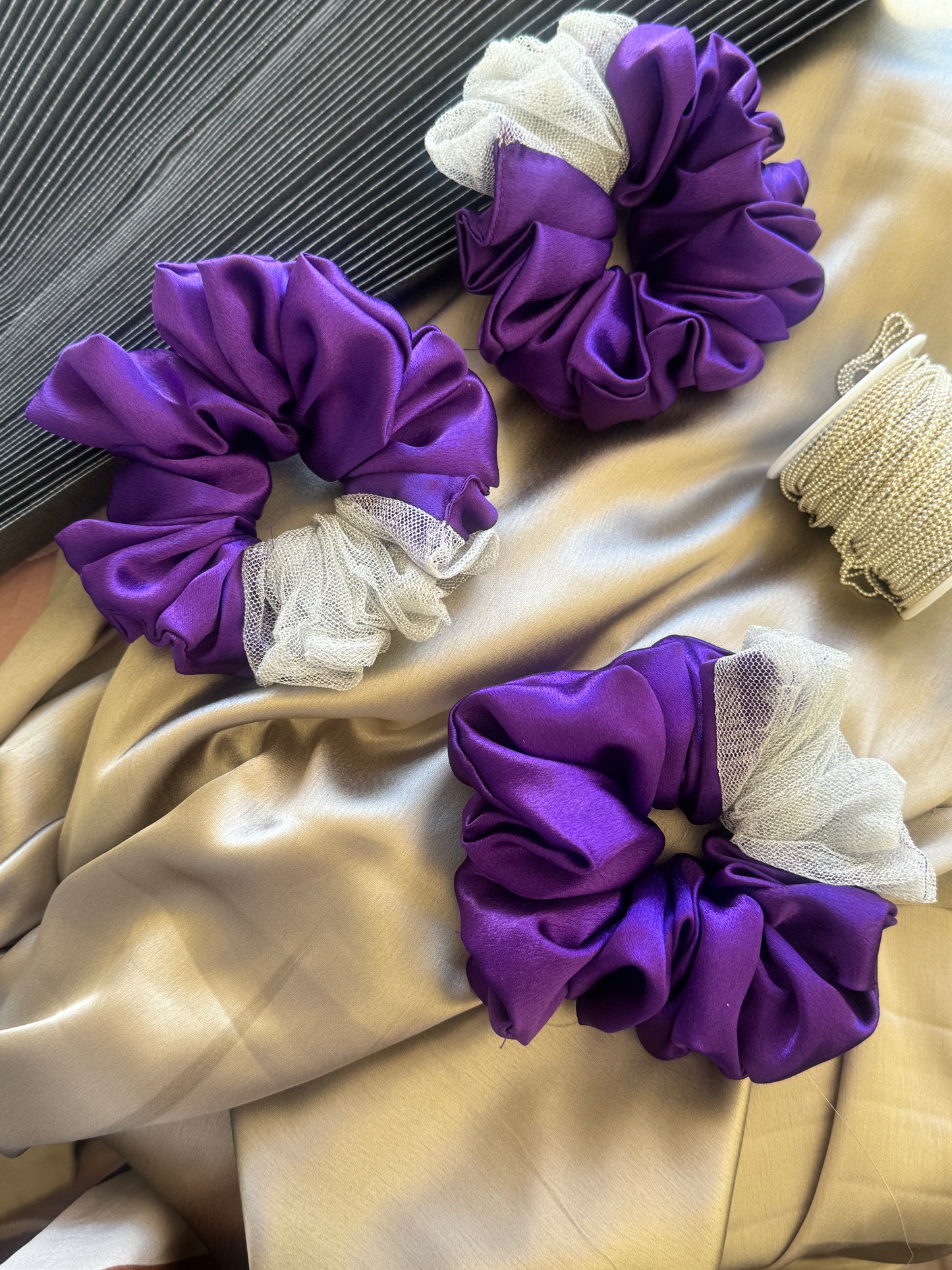 Multiple Purple Silver Snow Scrunchies - Front view of a collection of deep purple and shimmering silver satin and net scrunchies, perfect for casual, formal, or everyday styling.