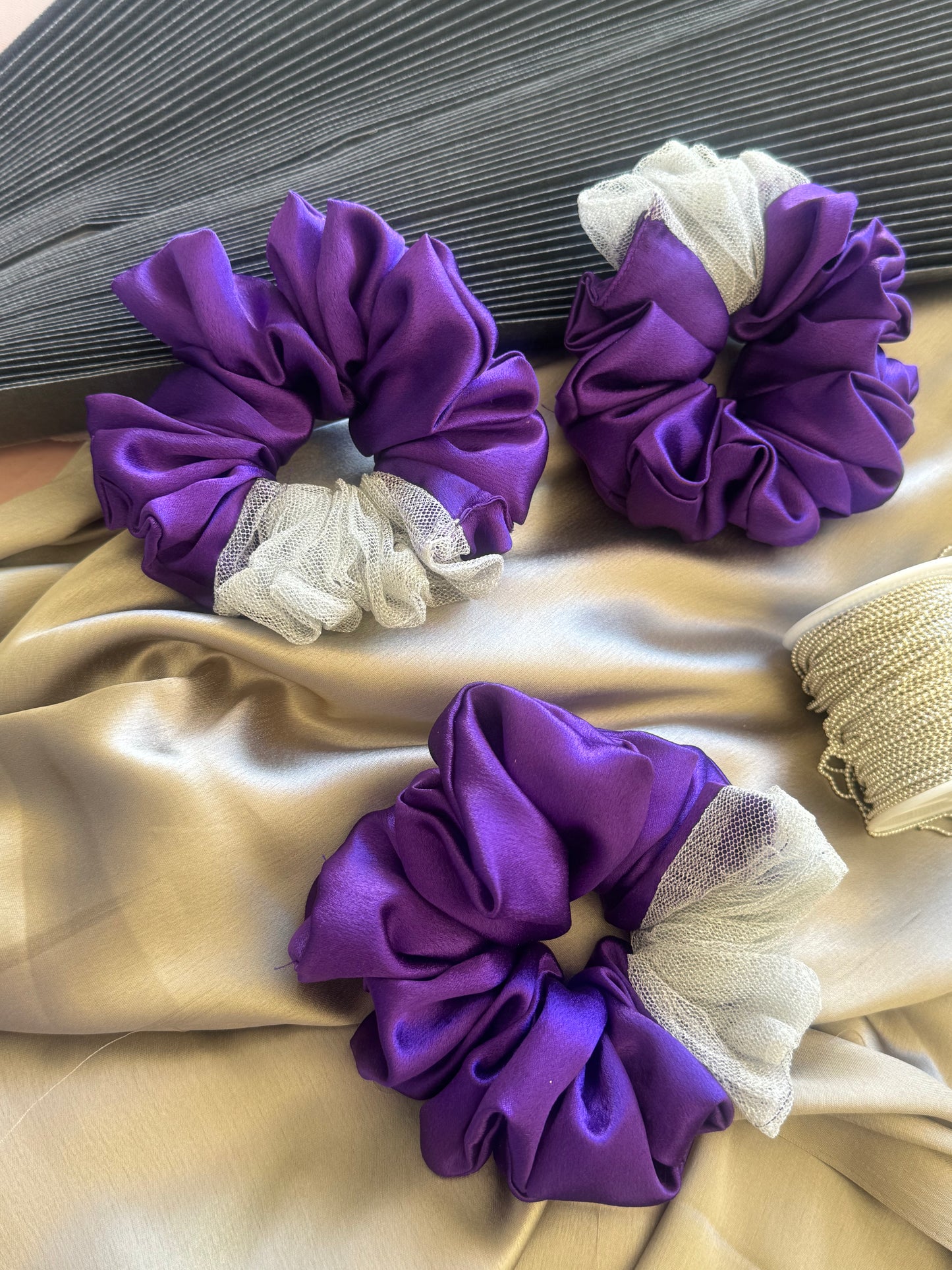 Multiple Purple Silver Snow Scrunchies - Front view of a collection of deep purple and shimmering silver satin and net scrunchies, perfect for casual, formal, or everyday styling.