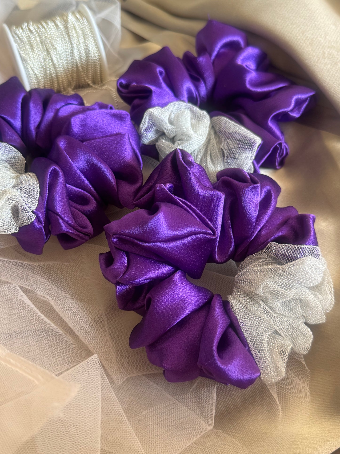 Multiple Purple Silver Snow Scrunchies - Front view of a collection of deep purple and shimmering silver satin and net scrunchies, perfect for casual, formal, or everyday styling.