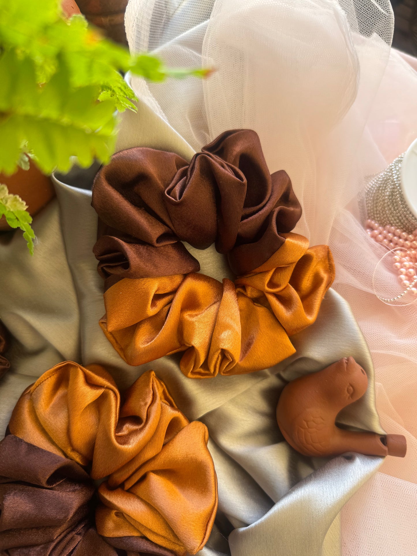 Set of two Terracotta Flower Scrunchies – earthy-toned satin hair accessories in earthen gold and rich brown, displayed front-facing