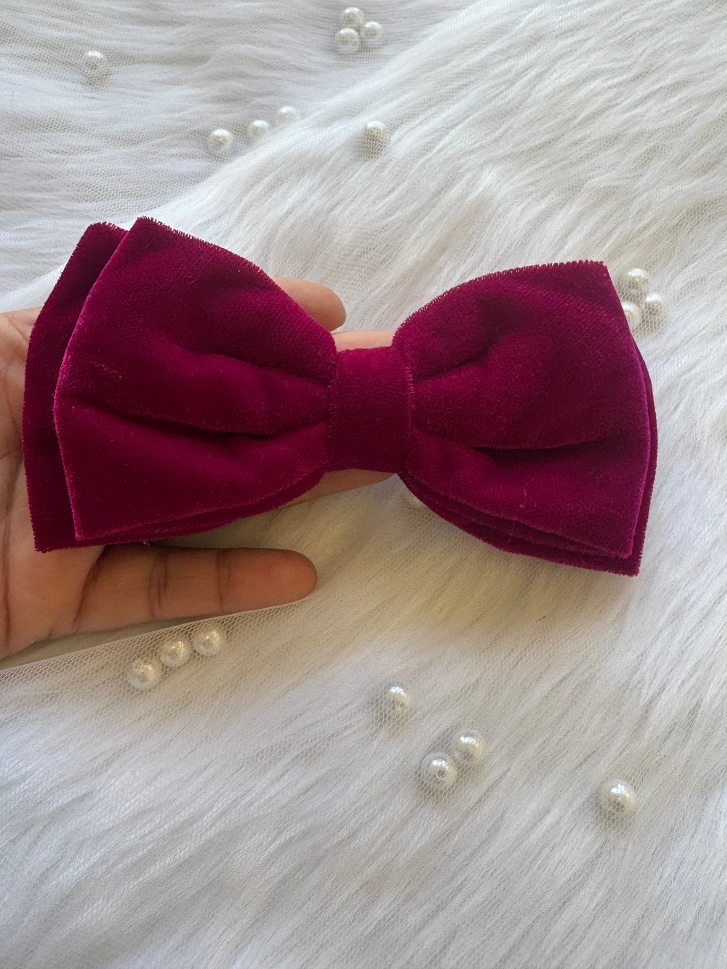 Runaway Diva Hair Bow Clip - Front view of a magenta pink premium velvet hair bow, expressing boldness and passion with timeless elegance. Held in palm for comparison.