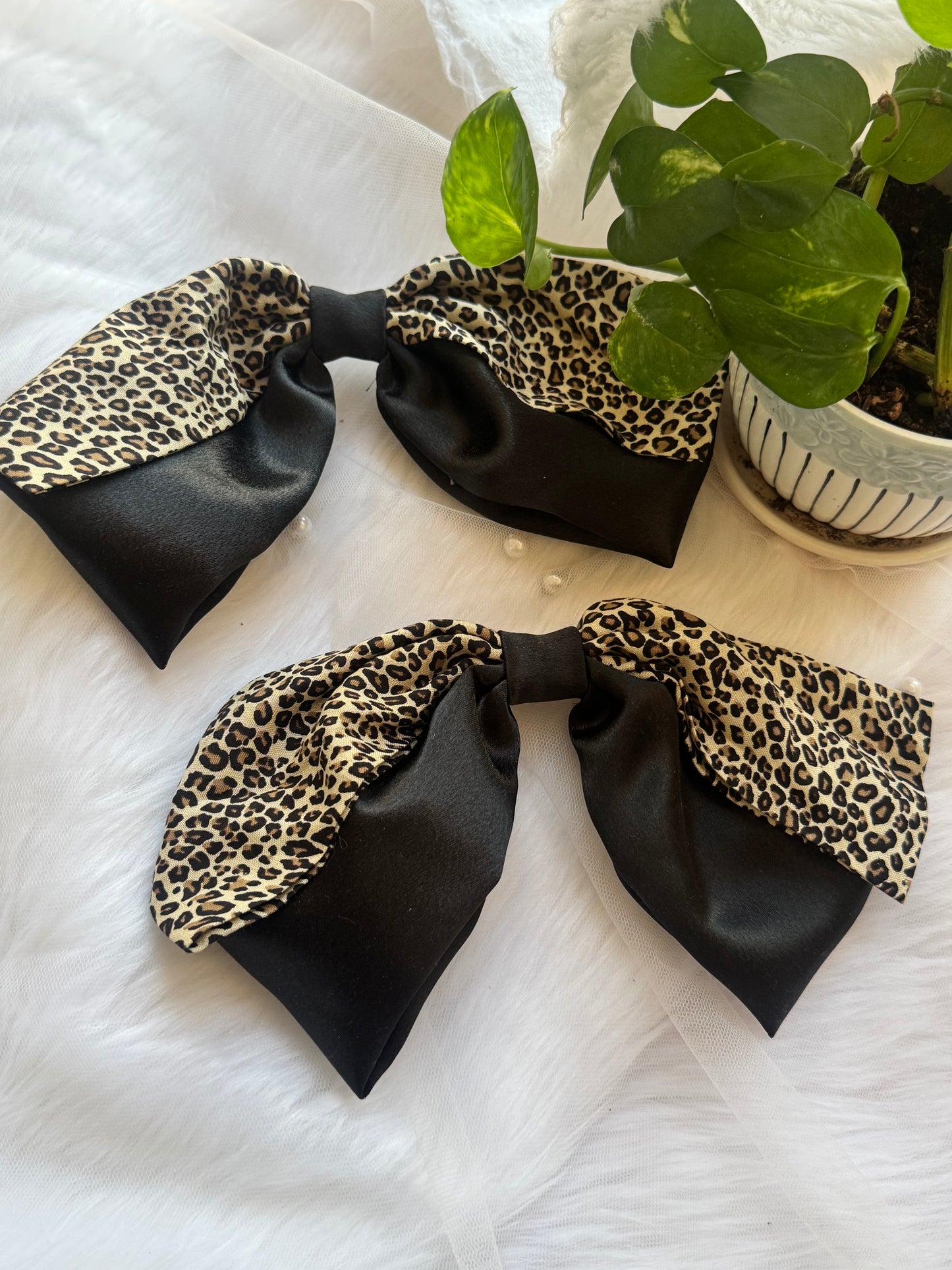 Two Kate Moss Hair Bows - Front view of oversized black satin and leopard print hair bow clips for bold, stylish looks
