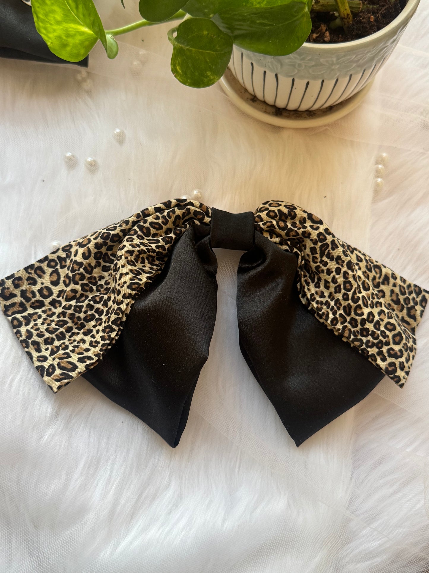 Kate Moss Hair Bow Clip - Oversized black satin and leopard print hair bow for bold, fashion-forward styling, bent to show flexibility.