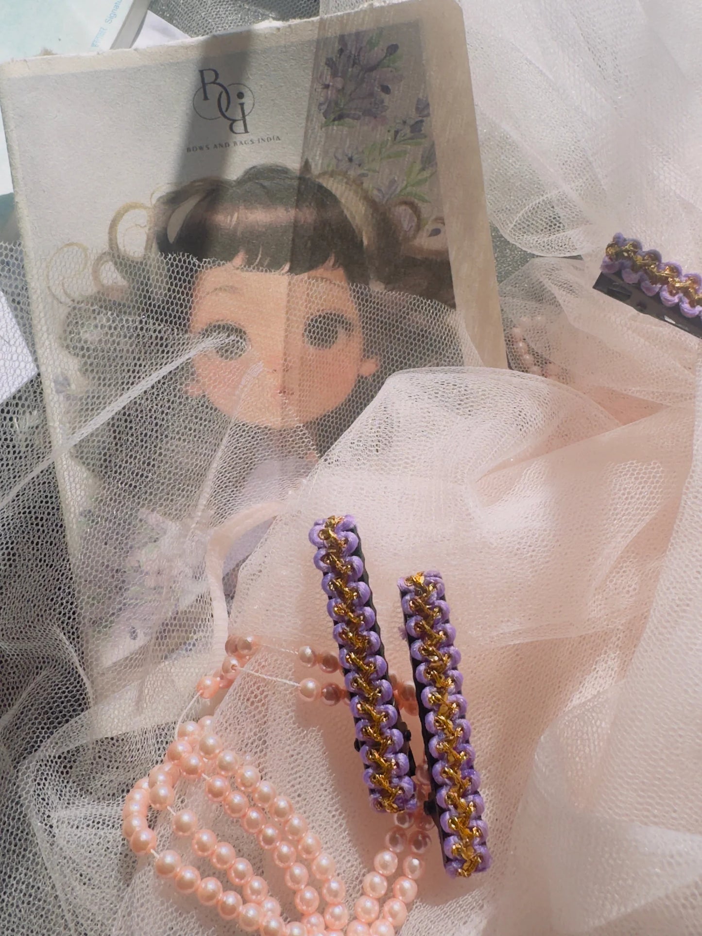 Lavender Paddy hair clips displayed with pearl beaded bracelets, handmade accessories from Bows and Bags India on tulle