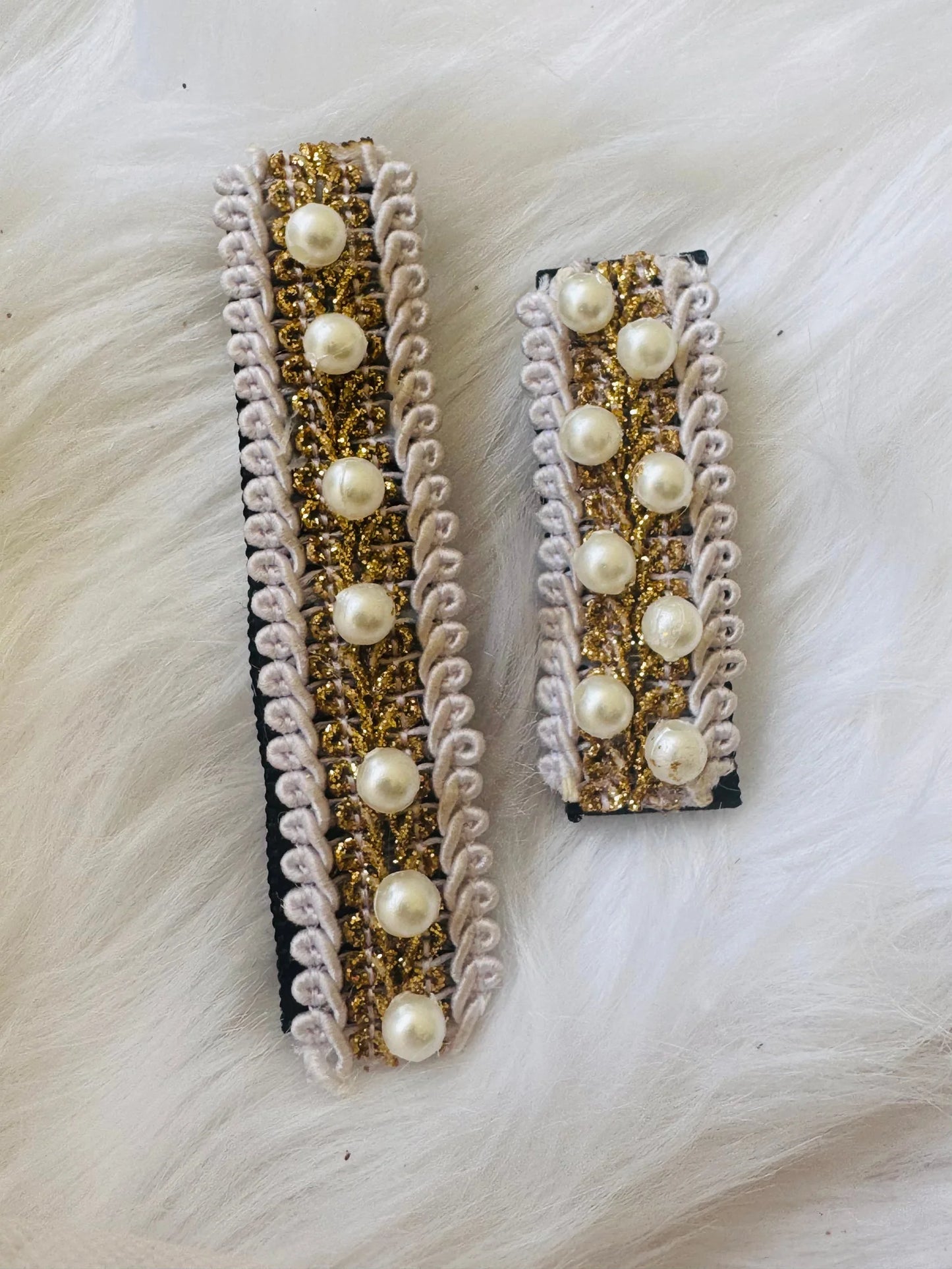 Pair of pearl-embellished handmade hair clips by Bows and Bags India with gold beading and white lace trim in medium and