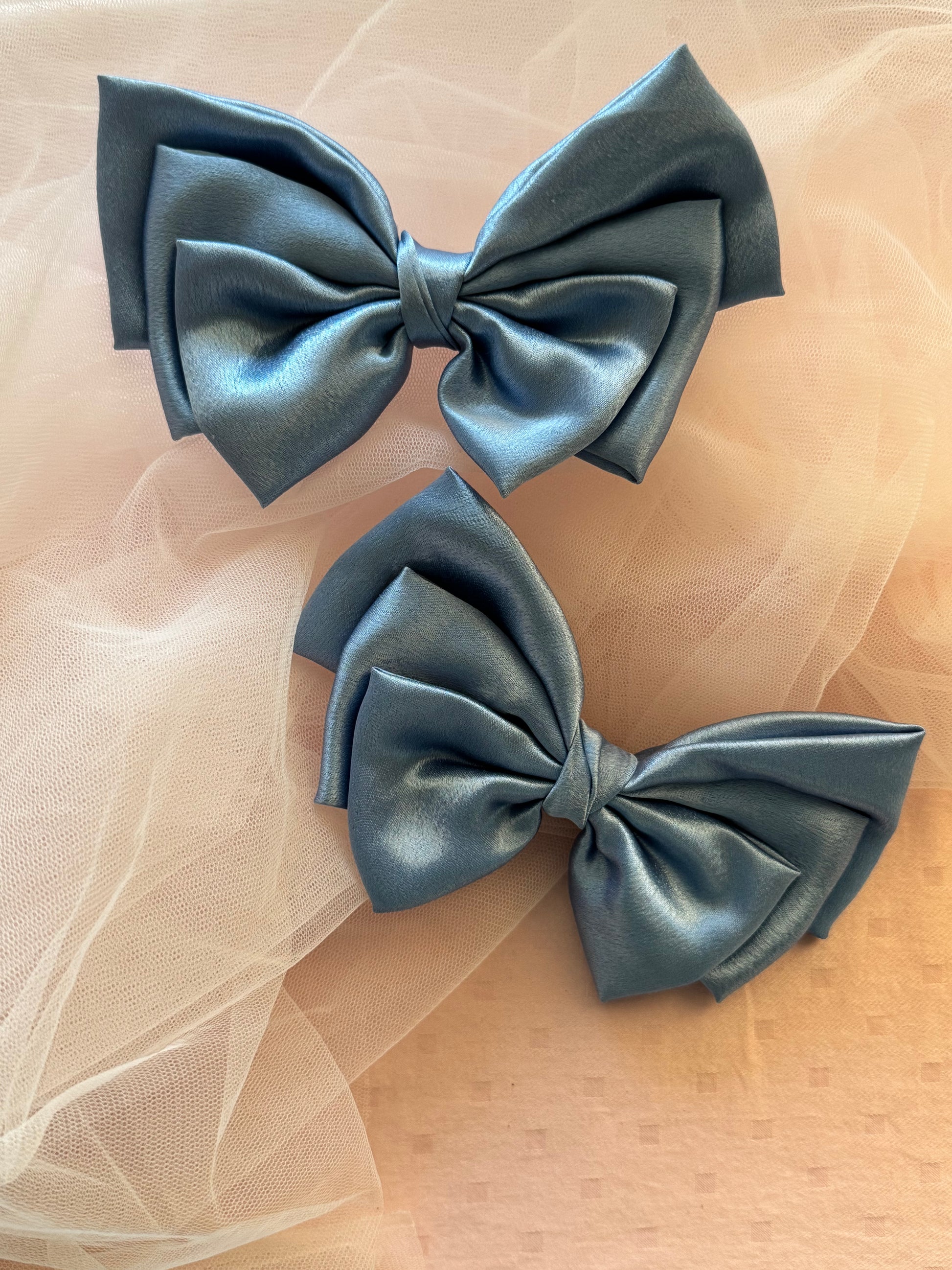 Two Ocean Drop Hair Bows - Front view of large metallic ice blue satin hair bow clips, perfect for adding a bold yet elegant statement to any hairstyle.