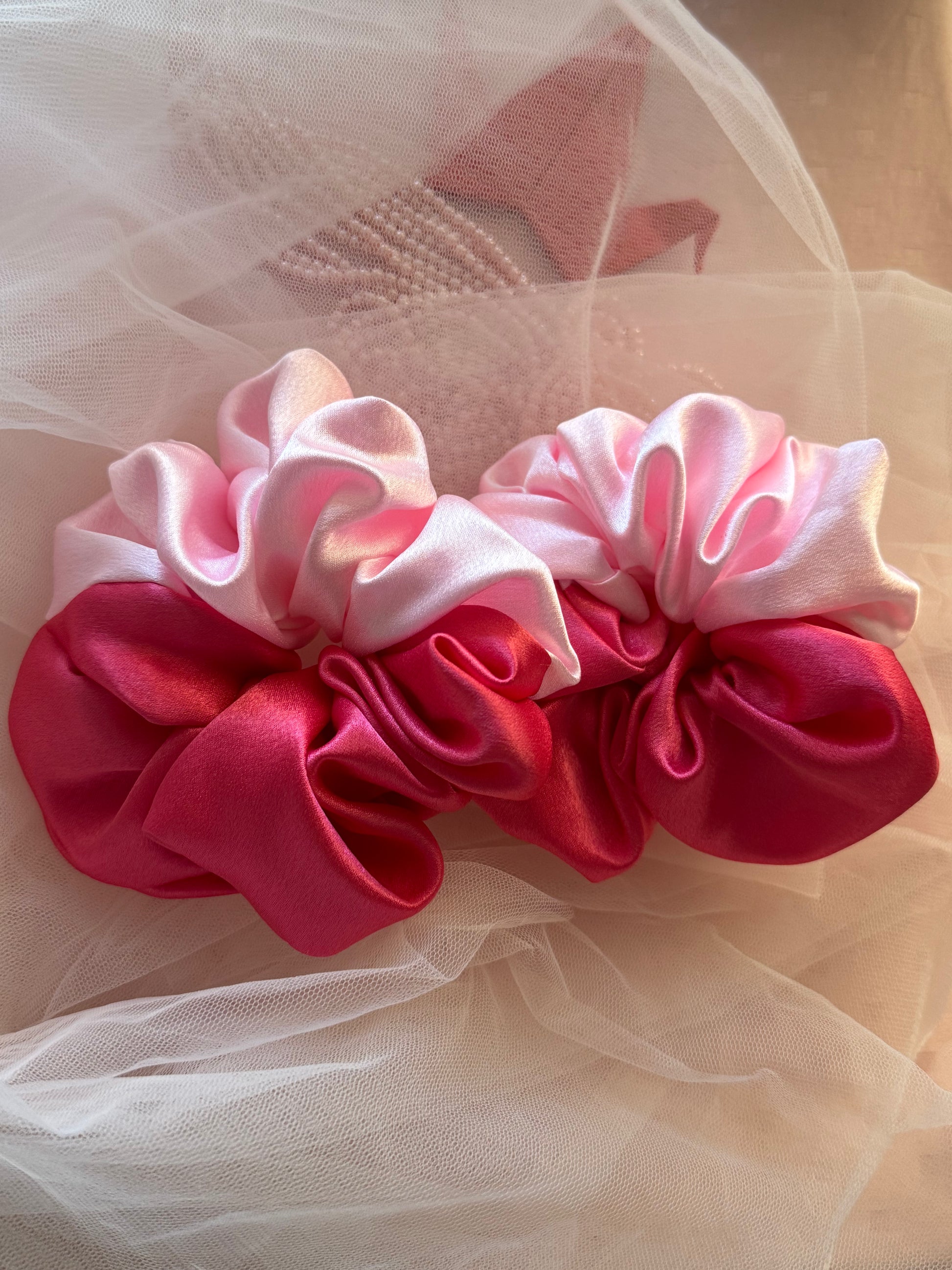 Two Scrunchies outlining the beautiful light and dark pink shades displayed with both colors Horizontally kept aligned parallely Close up