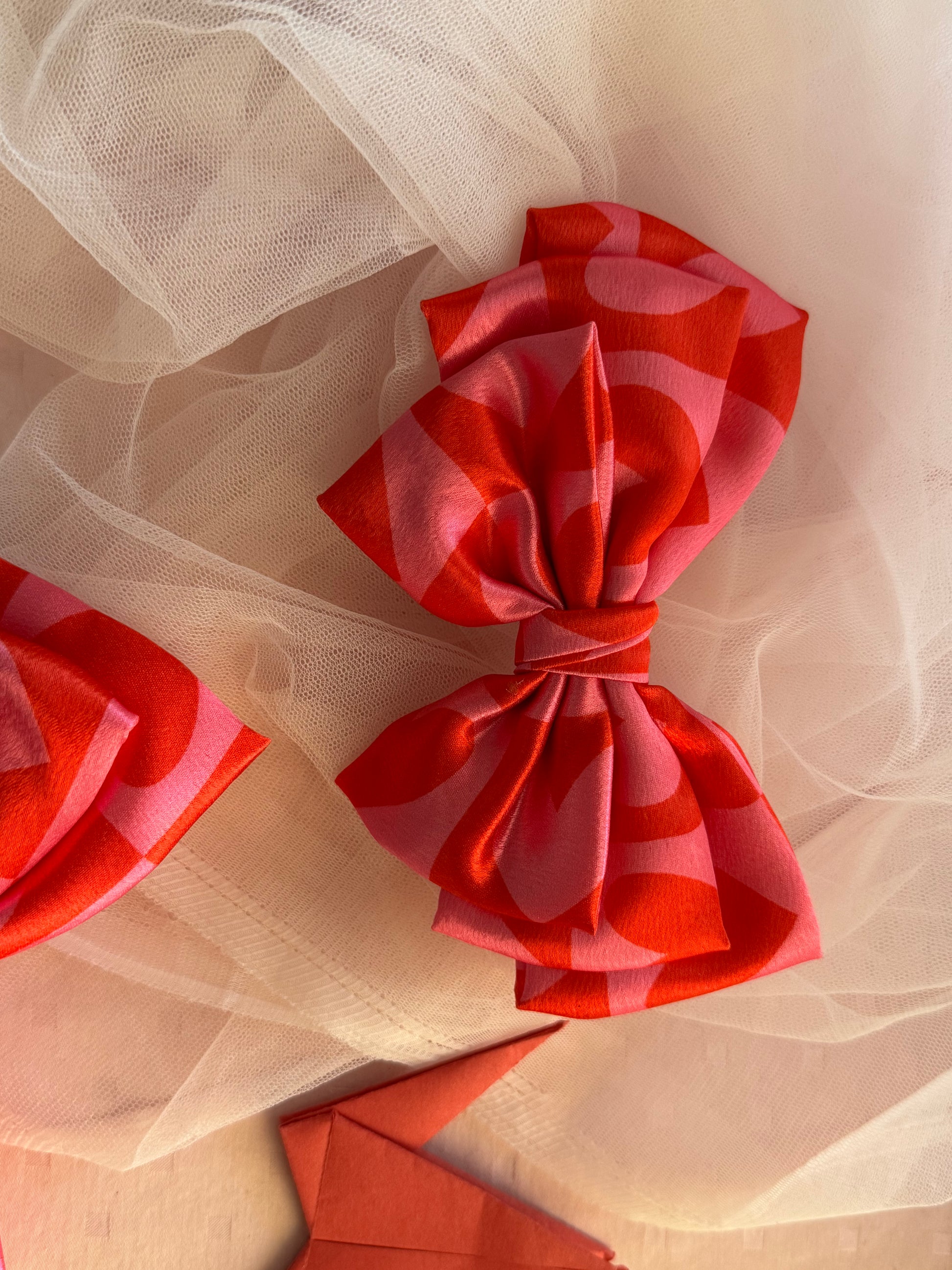 Love Struck Hair Bow Clip - Front view of a large pink satin hair bow with heart prints, radiating love and playfulness for a charming look