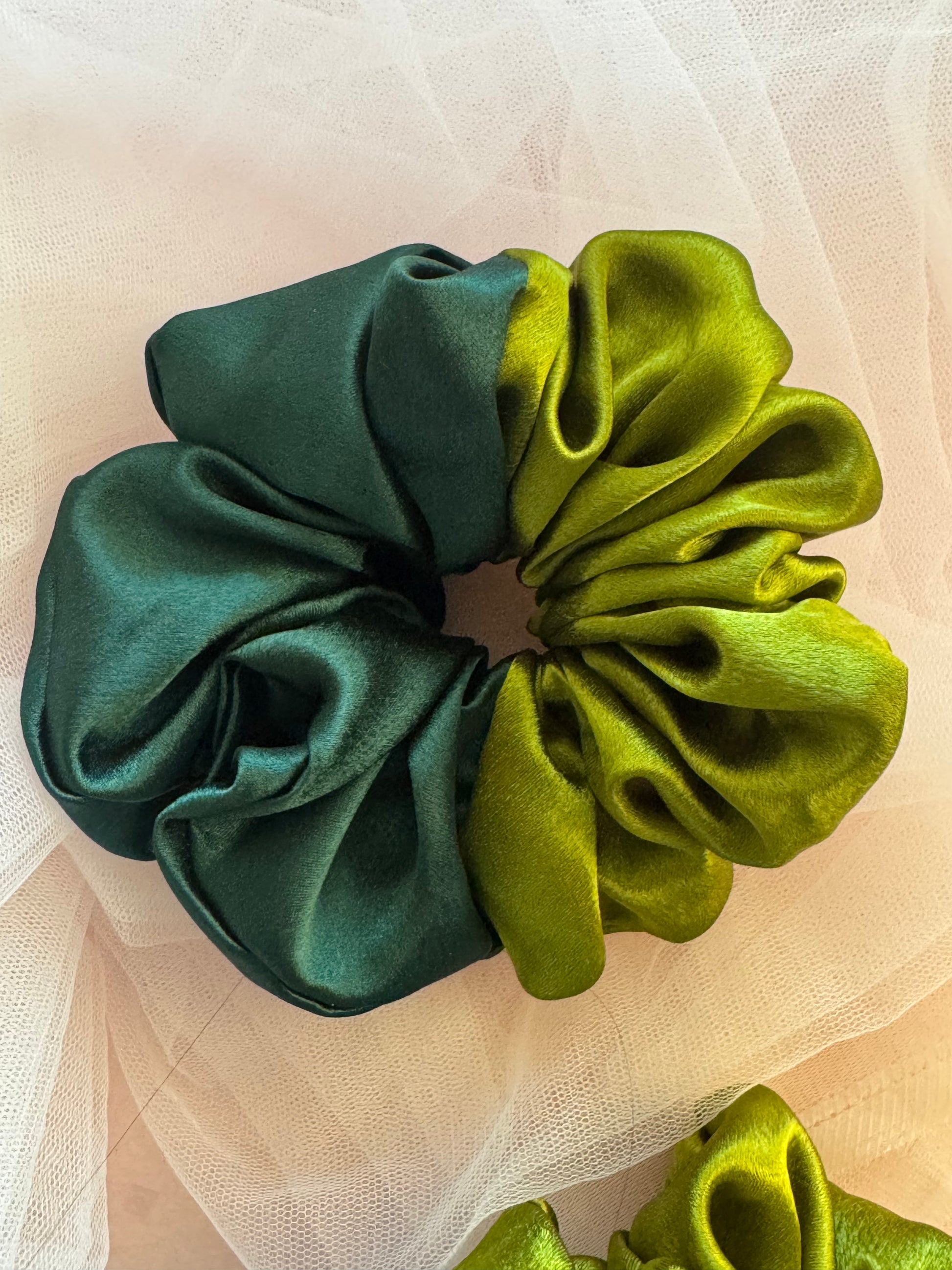 A luxurious olive and dark green dual-tone satin scrunchie for women, made from soft moss satin to reduce hair breakage, perfect for ponytails, buns, and stylish hair accessories.