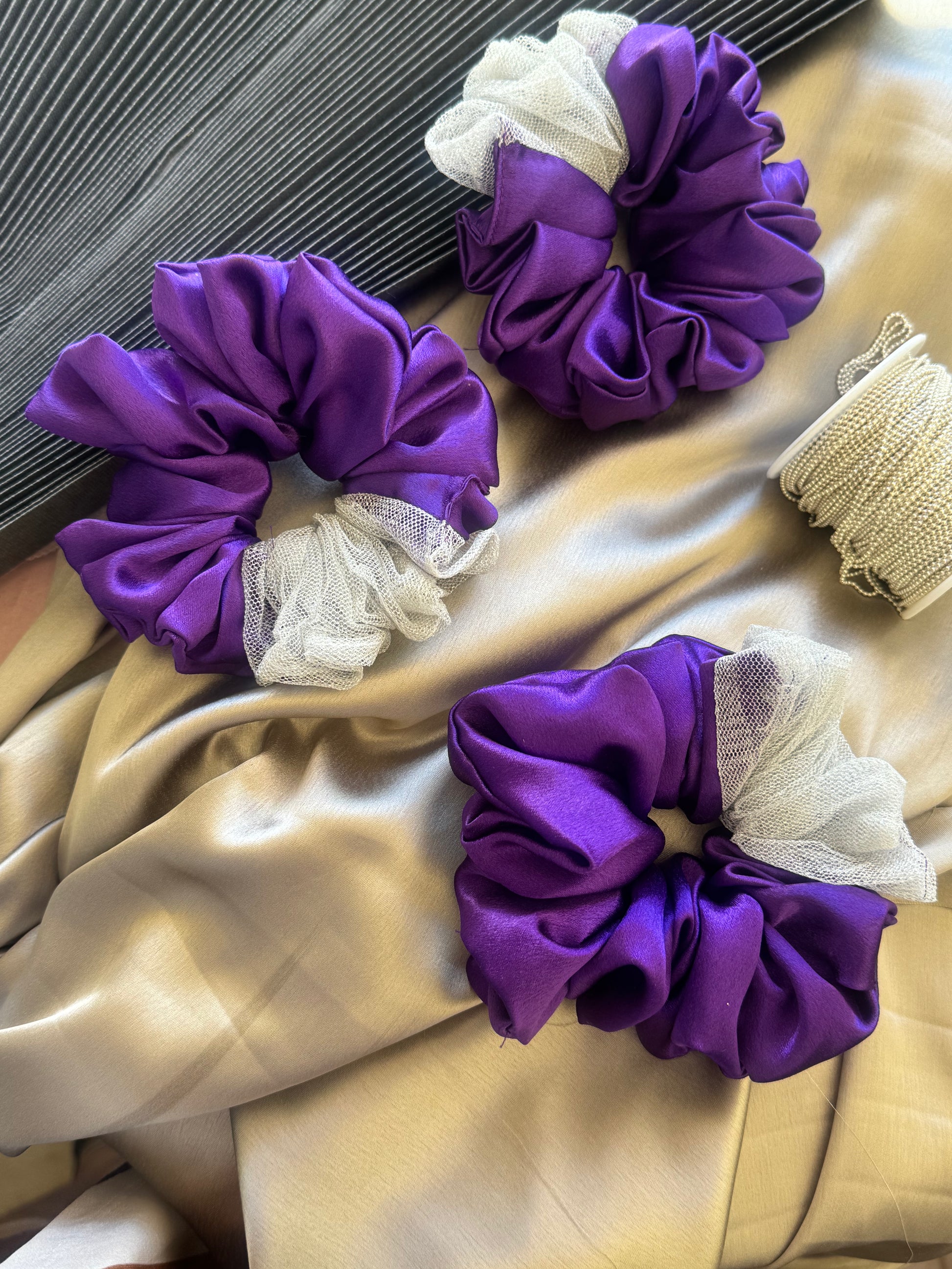 Multiple Purple Silver Snow Scrunchies - Front view of a collection of deep purple and shimmering silver satin and net scrunchies, perfect for casual, formal, or everyday styling.