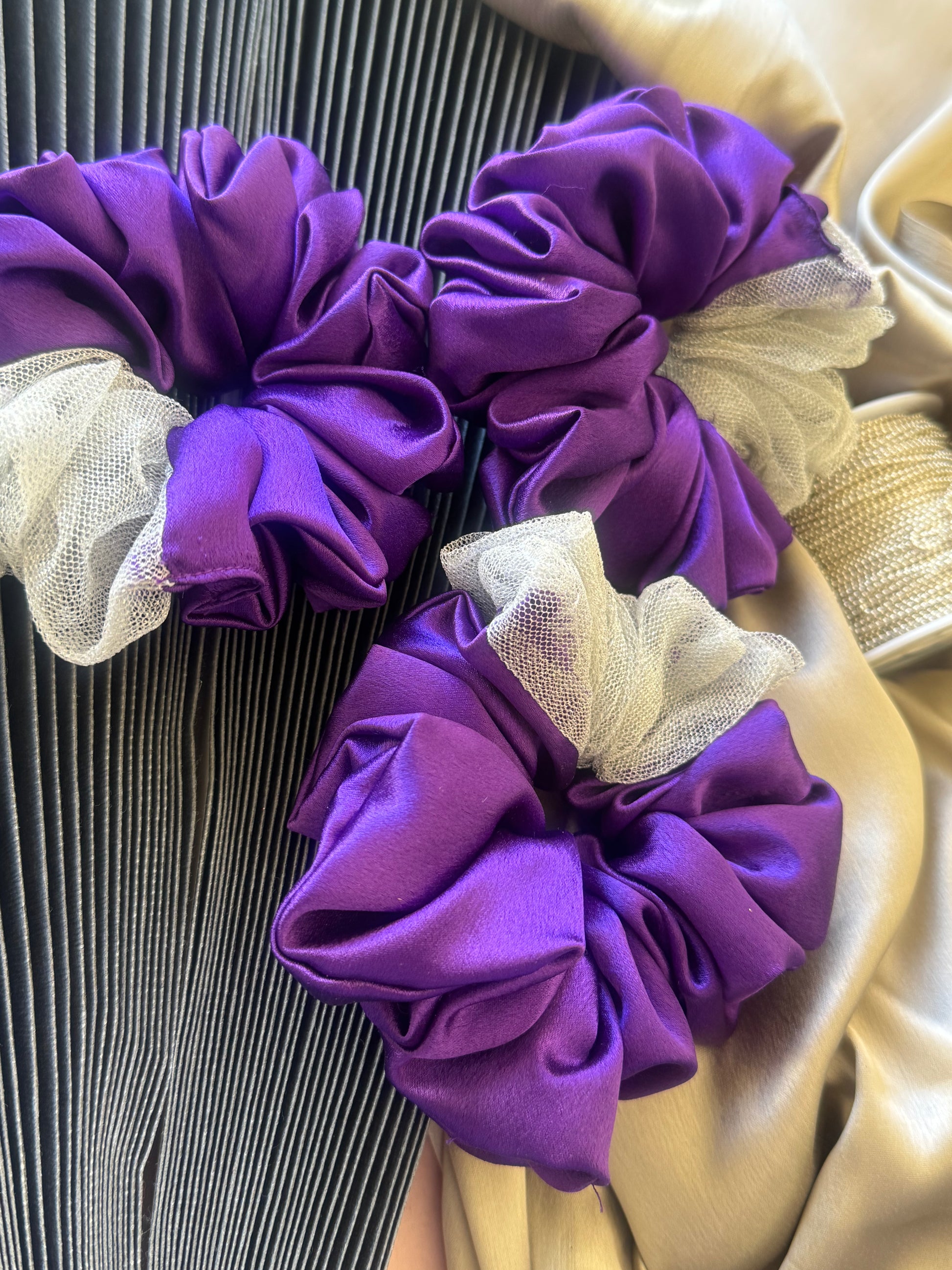Multiple Purple Silver Snow Scrunchies - Front view of a collection of deep purple and shimmering silver satin and net scrunchies, perfect for casual, formal, or everyday styling.