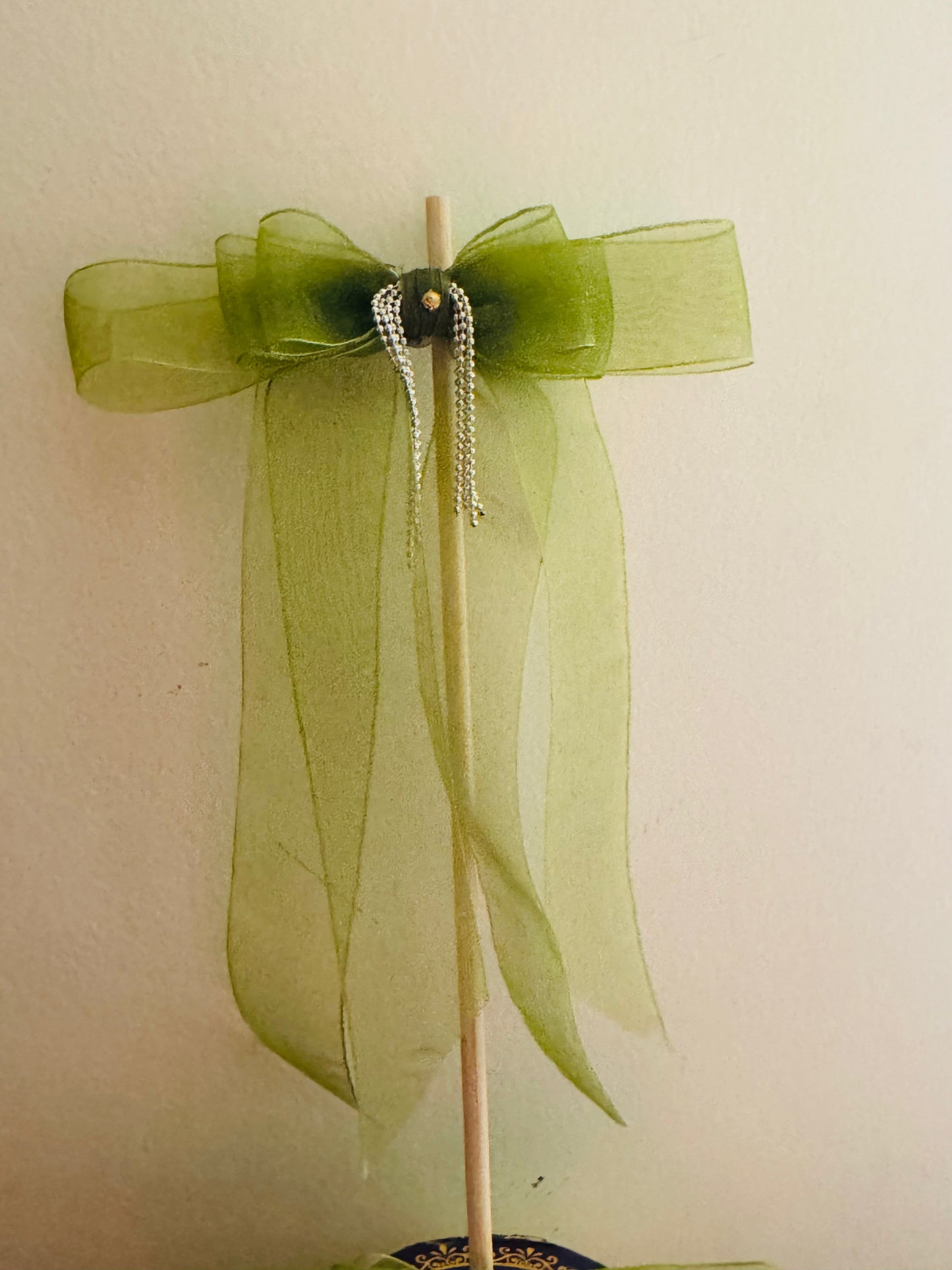 Tinker Bell Hair Bow Clip - Front view of a light green organza hair bow with a delicate silver chain detail for a graceful and elegant look. Mounted on a stick.