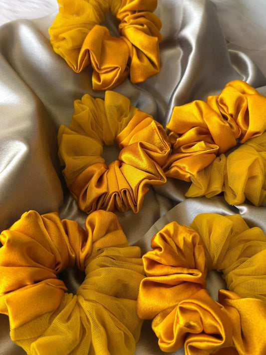 Mustard yellow satin and net scrunchies by Bows and Bags India arranged on white fabric, showing handmade hair accessories