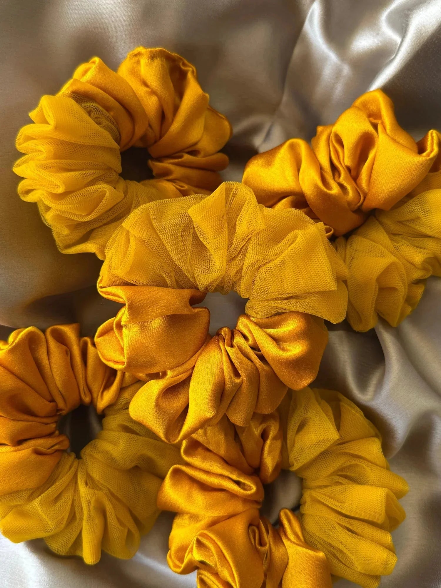 Closeup of mustard yellow satin and net scrunchies by Bows and Bags India showing textured fabric detail and layered ruffle