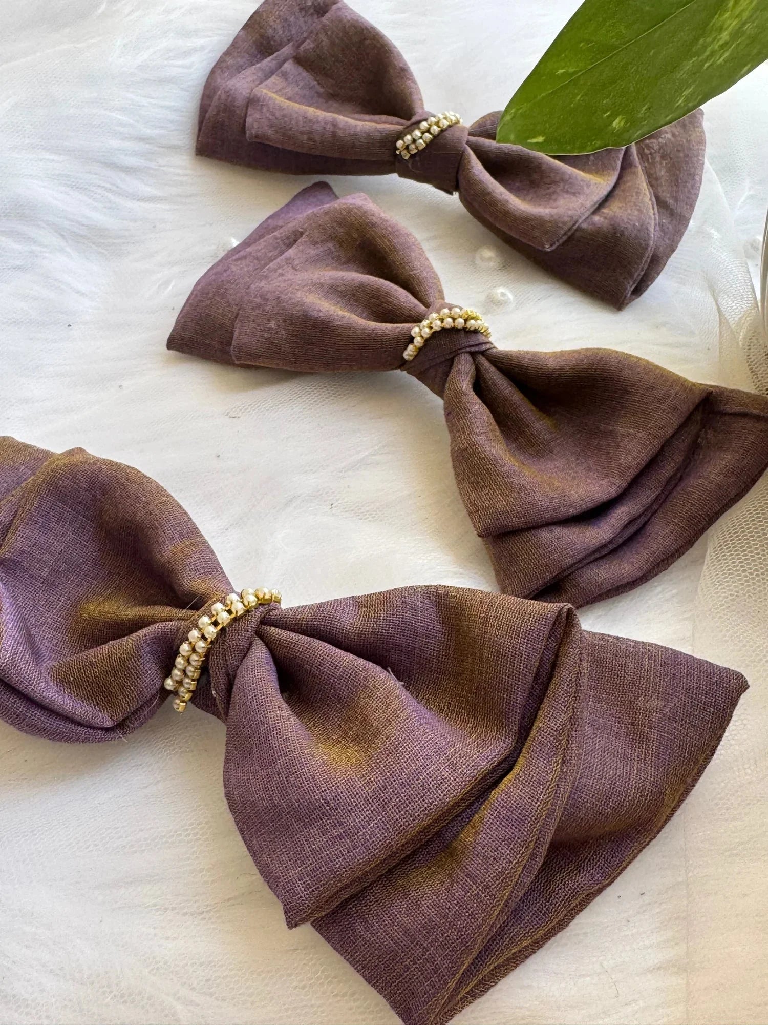 Three handmade Blackcurrant Ice hair bow clips in dual-tone violet and brown cotton with pearl embellishments by Bows and
