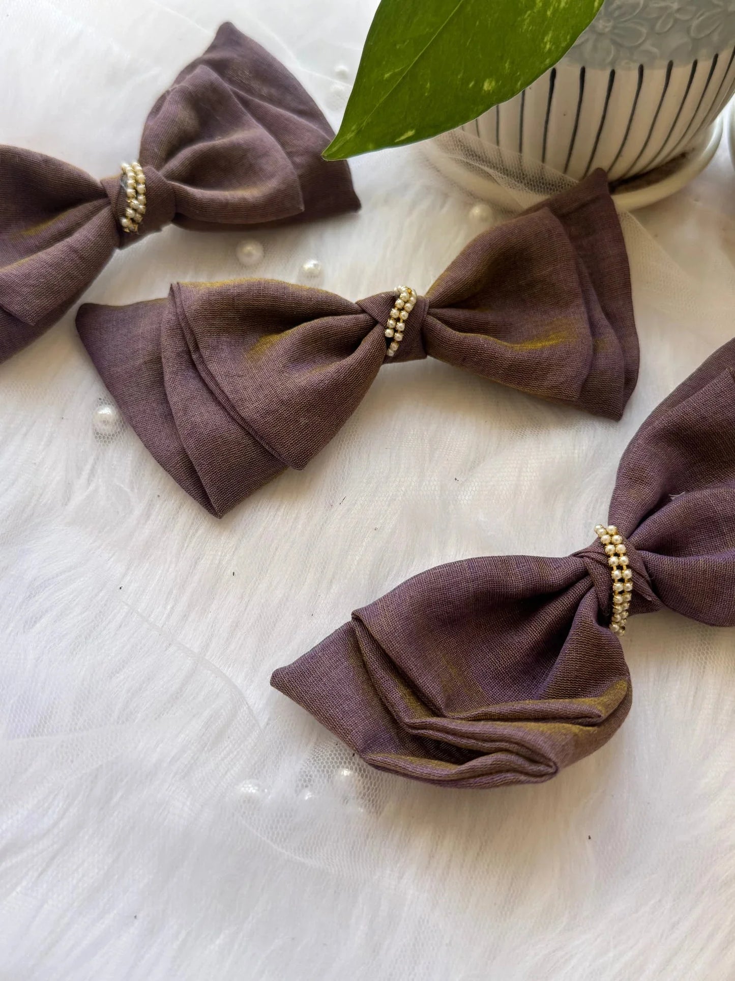 Three handmade cotton hair bow clips in blackcurrant violet with pearl beading, flat lay styling detail by Bows and Bags
