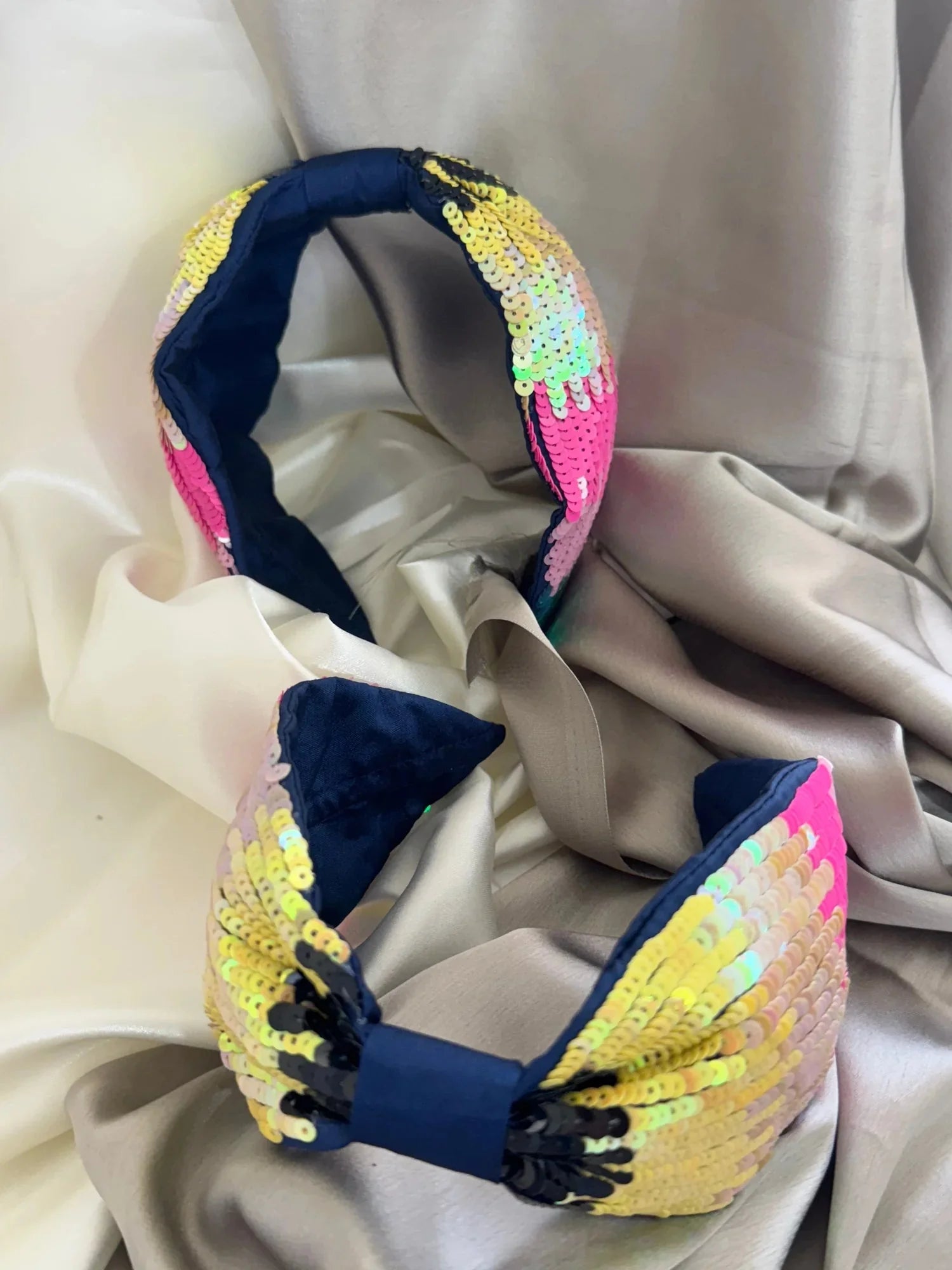 Handmade multicolor sequin and beaded satin headband by Bows and Bags India with navy blue base, displayed on neutral fabric
