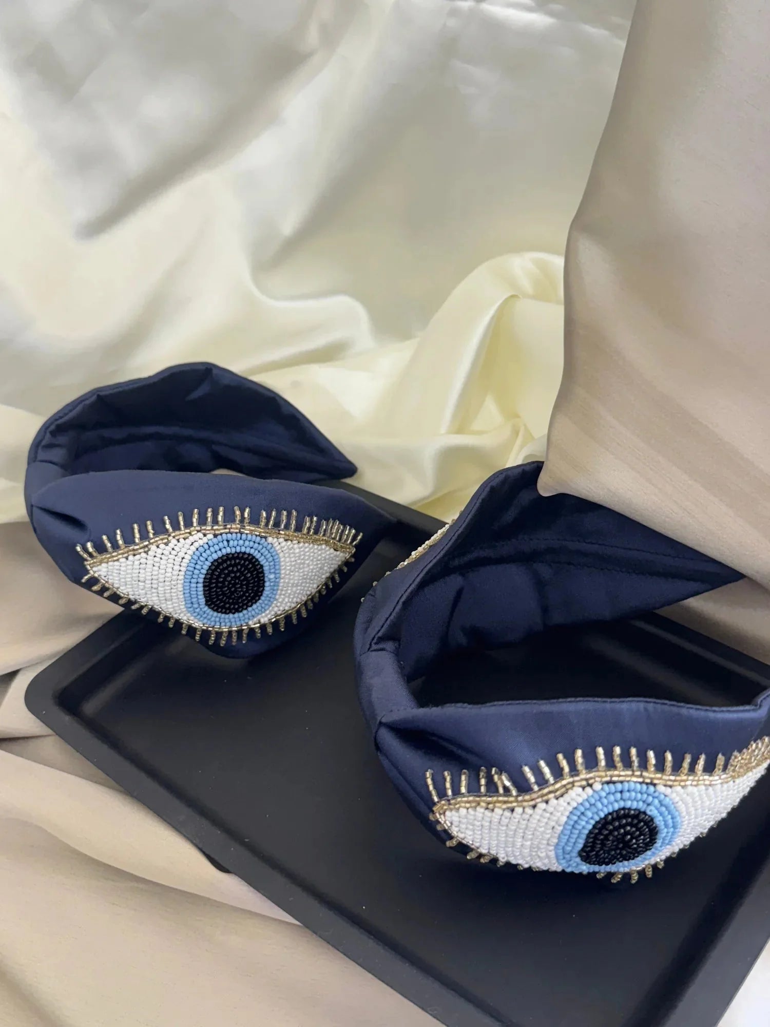 Navy blue satin handmade beaded headband with evil eye design from Bows and Bags India, detailed close-up view