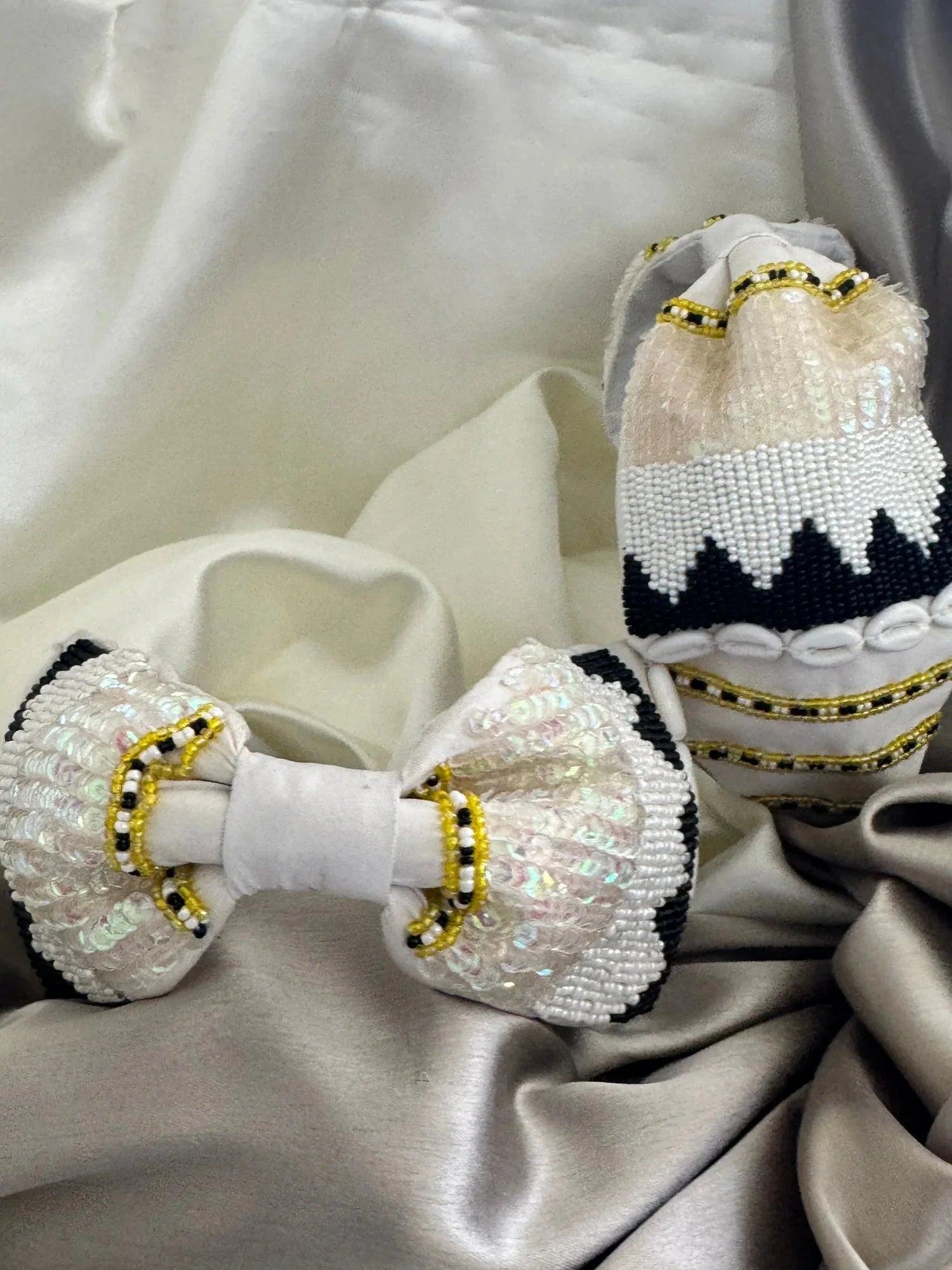 Handcrafted beaded white satin headband with gold accents by Bows and Bags India, displayed on luxurious fabric backdrop