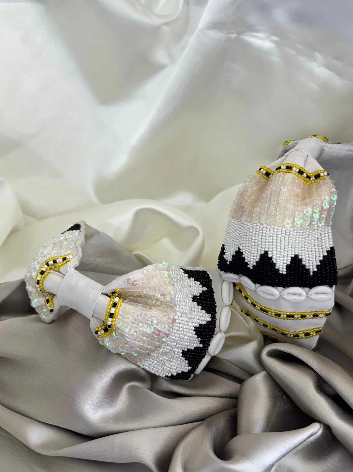 Three white satin handmade headbands with beaded gold and black detailing by Bows and Bags India, displayed on elegant fabric