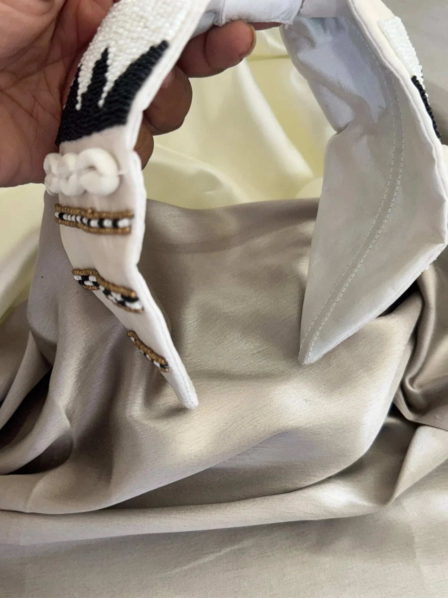 Handmade beaded white satin headband with shell details by Bows and Bags India, close-up texture view