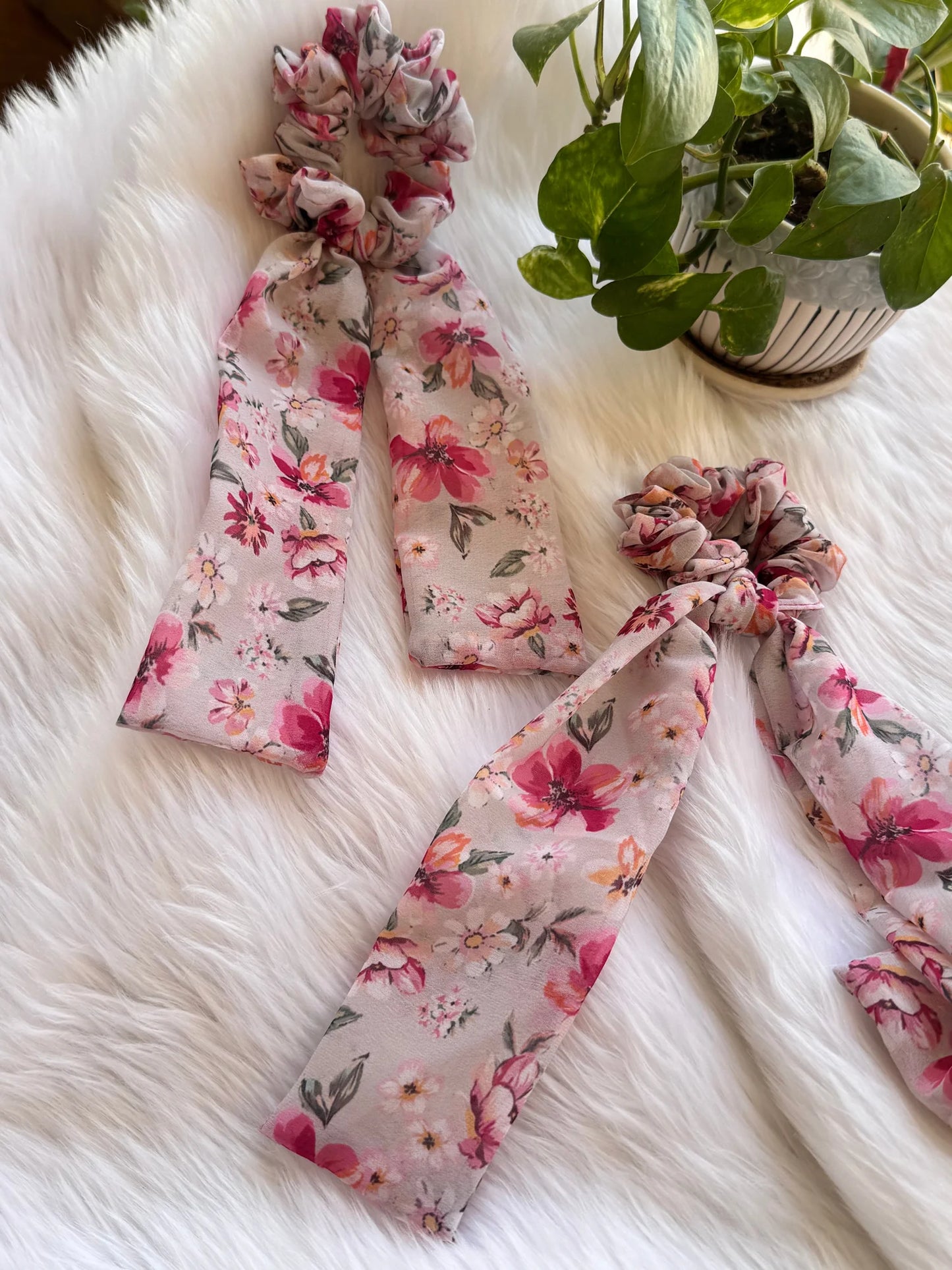 Floral pink georgette tail scrunchies arranged on white fur, lifestyle flat lay display by Bows and Bags India