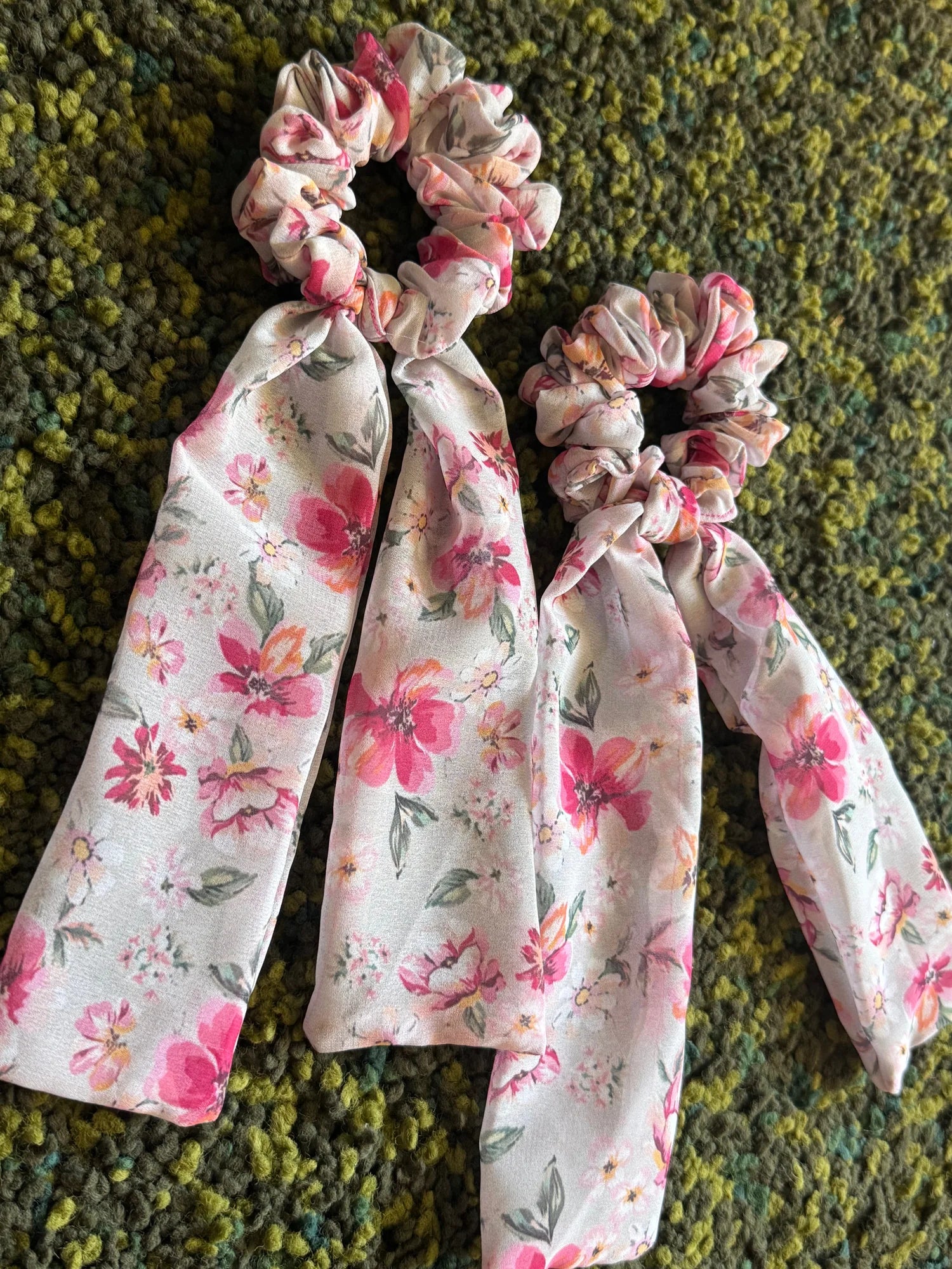 Floral pink georgette tail scrunchie with two delicate tails displayed on textured fabric by Bows and Bags India