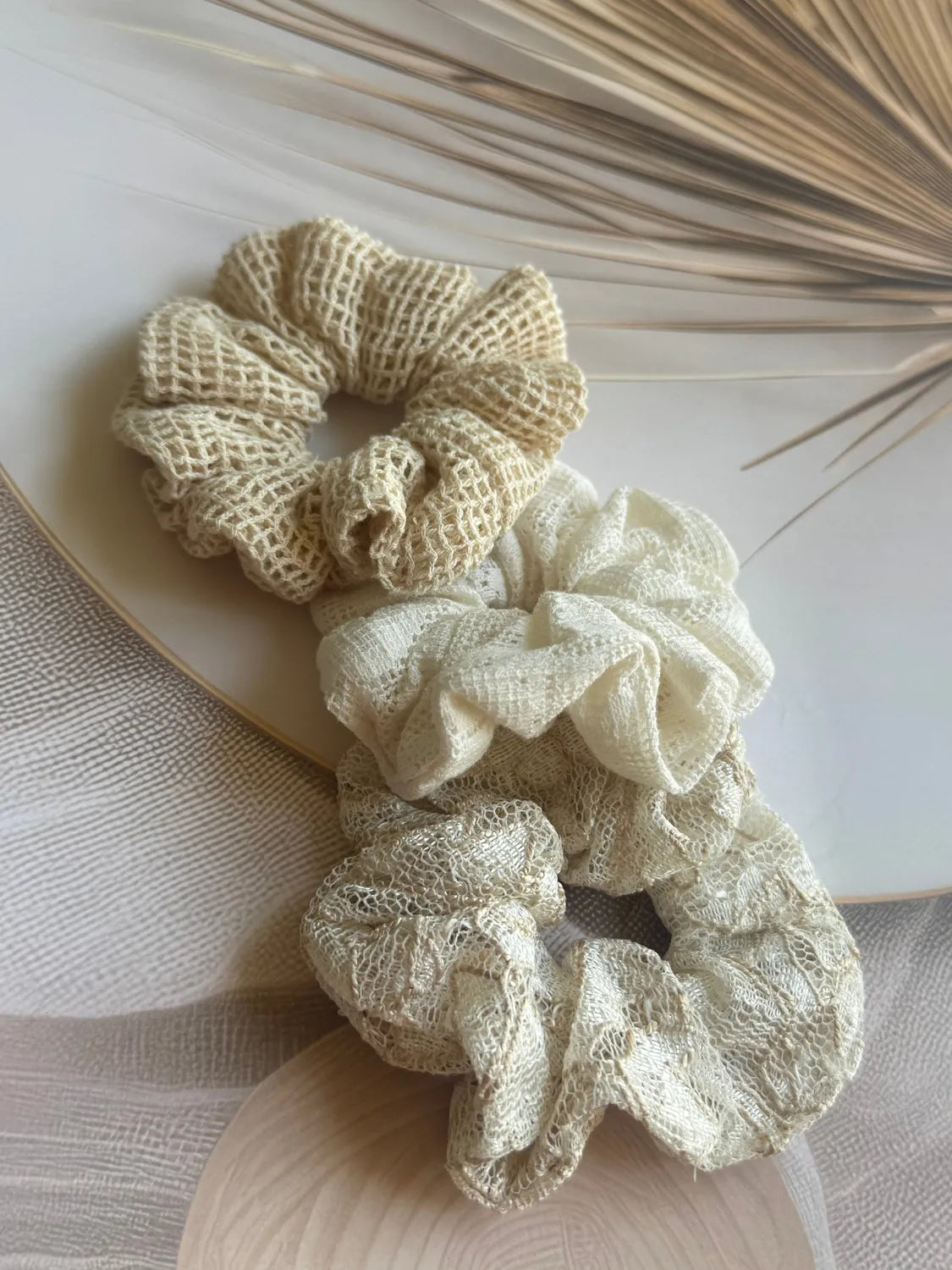 Three handmade net mesh scrunchies in cream and beige tones by Bows and Bags India, displayed flat showing boho texture and
