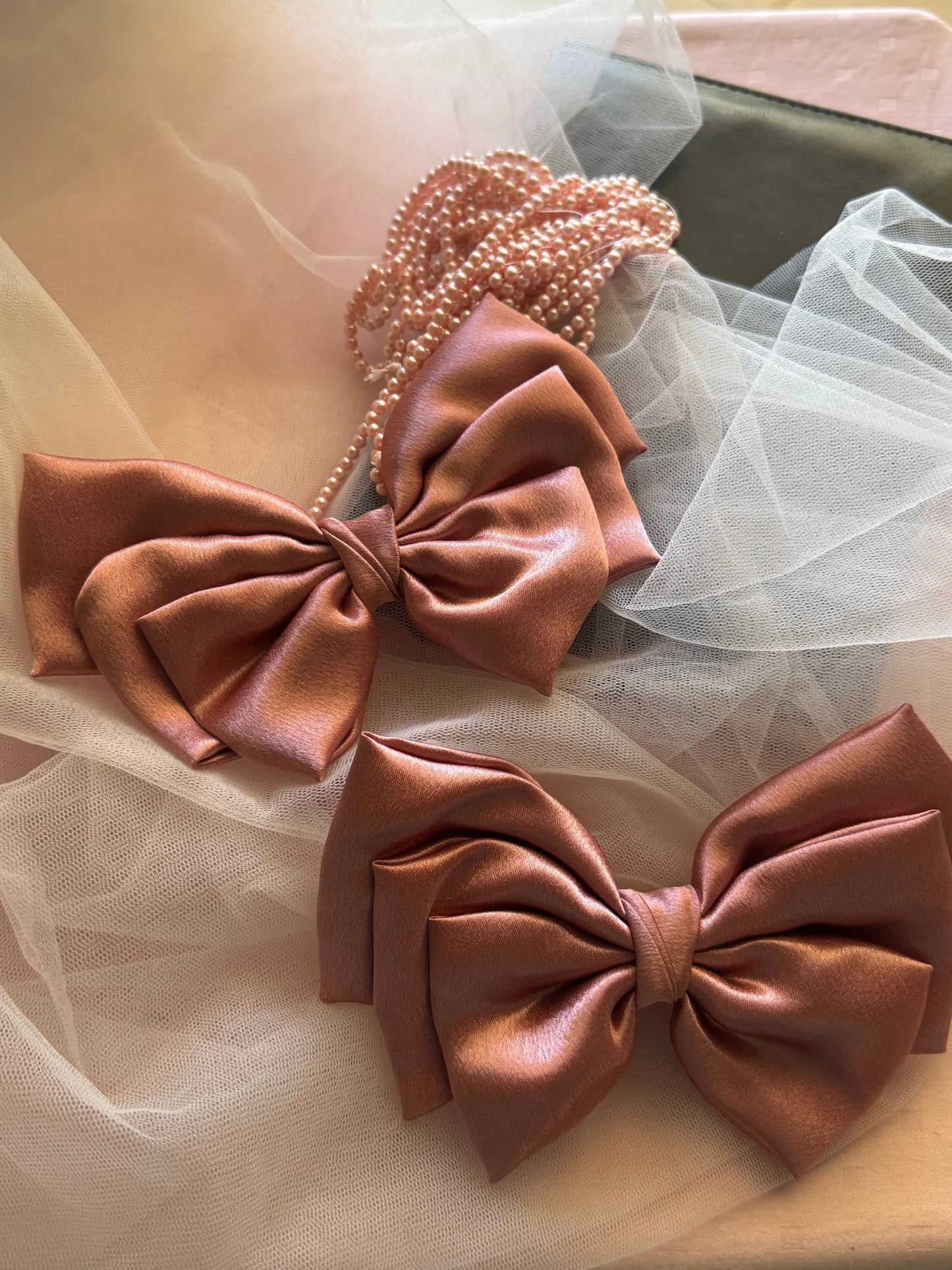 Metallic peach satin hair bow by Bows and Bags India displayed with pearl beaded headband and tulle, showcasing handmade