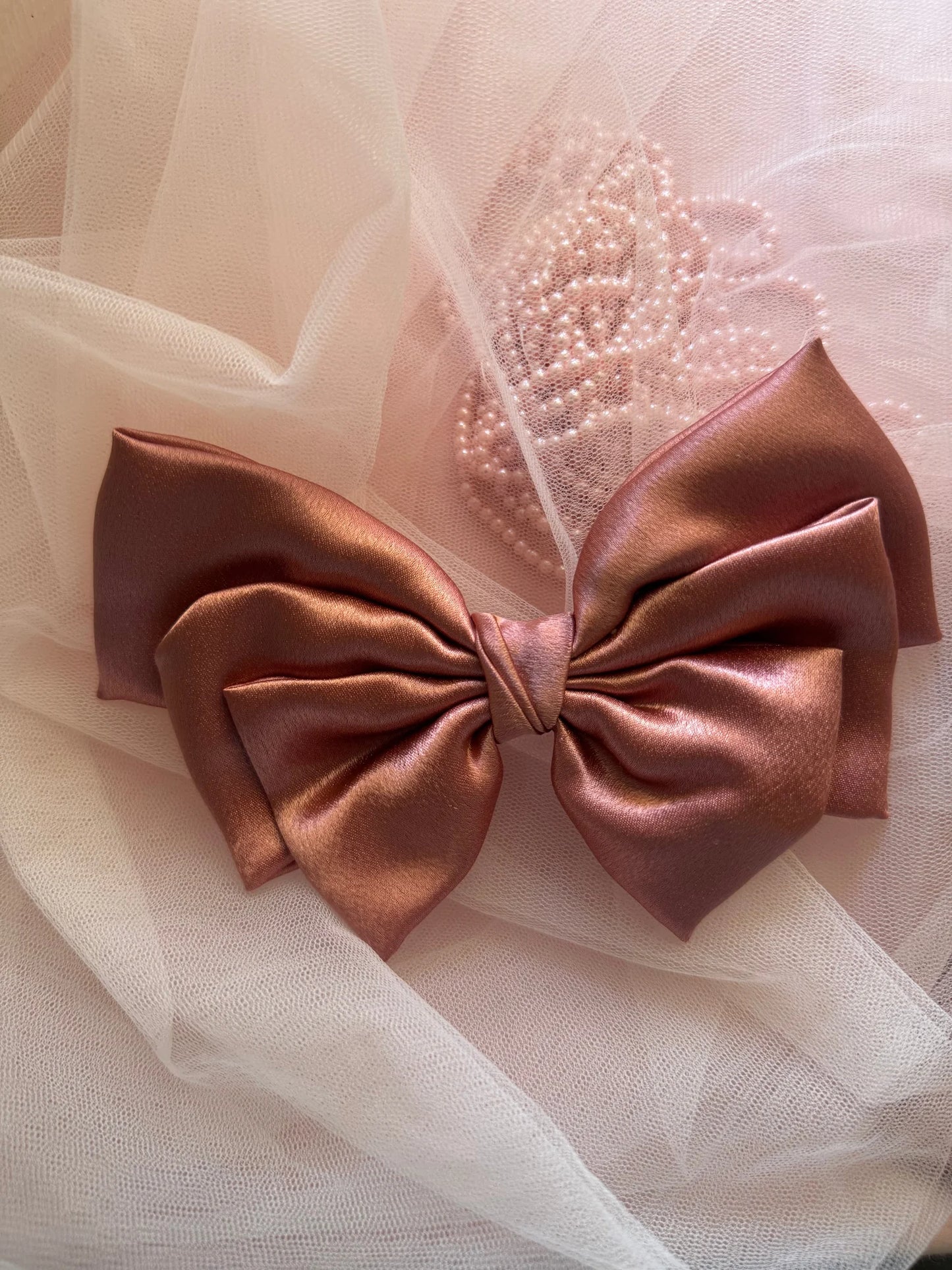Metallic peach satin hair bow detail with pearl beading on tulle backdrop by Bows and Bags India