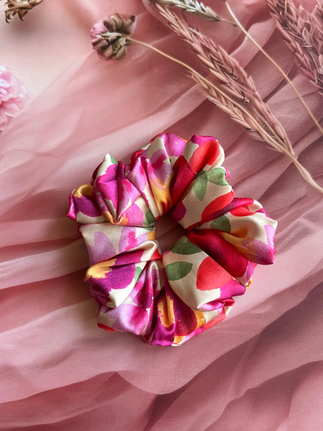 Floral print XL satin scrunchie by Bows and Bags India displayed on pink fabric with dried botanicals, showing vibrant