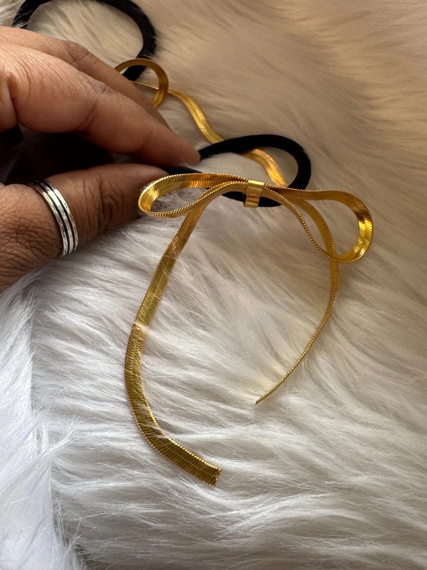 Golden Chain bow metal hair tie in gold with black elastic band held in hand, Bows and Bags India handmade accessory detail
