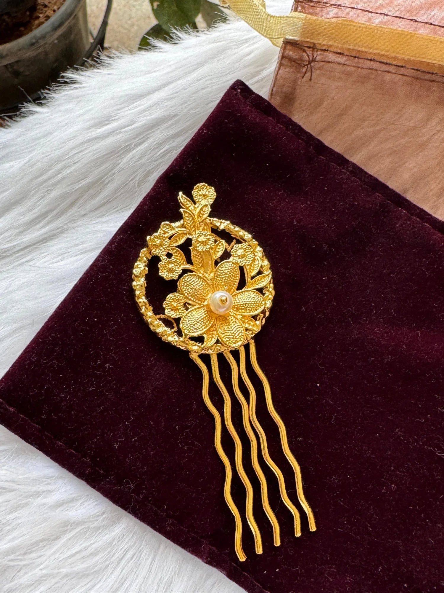 Golden Flora hair pin with intricate textured flowers and pearl center on burgundy velvet by Bows and Bags India