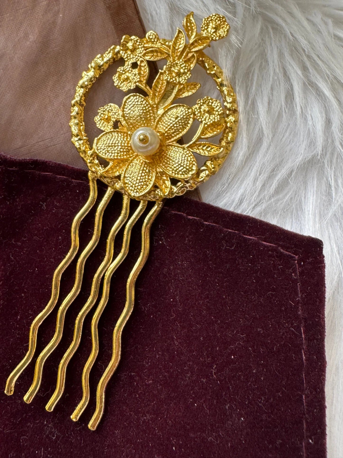 Golden Flora hair pin by Bows and Bags India displaying intricate textured gold flowers with pearl center and wavy prongs on