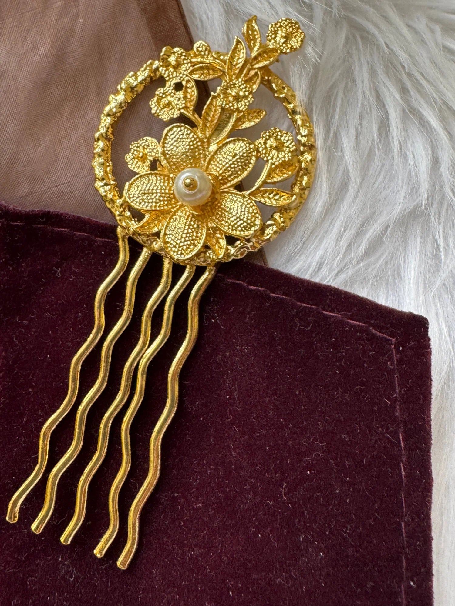 Golden Flora hair pin by Bows and Bags India displaying intricate textured gold flowers with pearl center and wavy prongs on