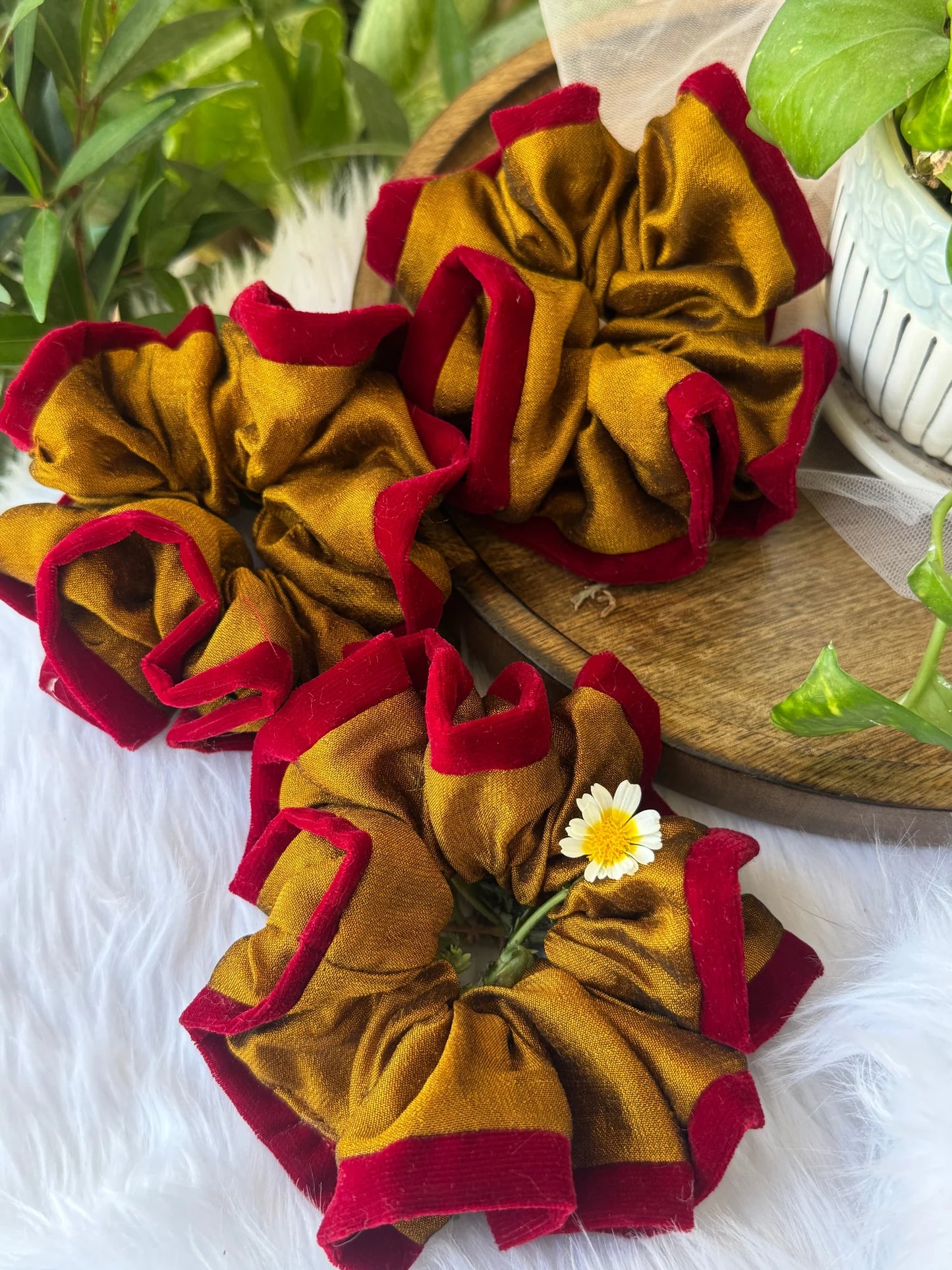 Golden yellow silk scrunchies with maroon velvet trim by Bows and Bags India, handmade hair accessories displayed on wooden