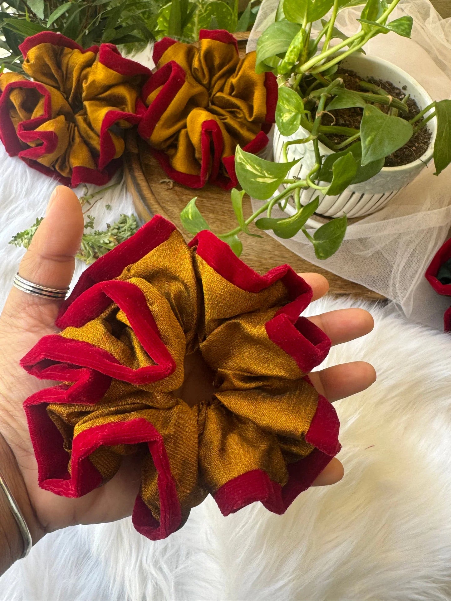 Golden yellow and maroon velvet silk scrunchie held in hand by Bows and Bags India, handmade hair accessory detail shot