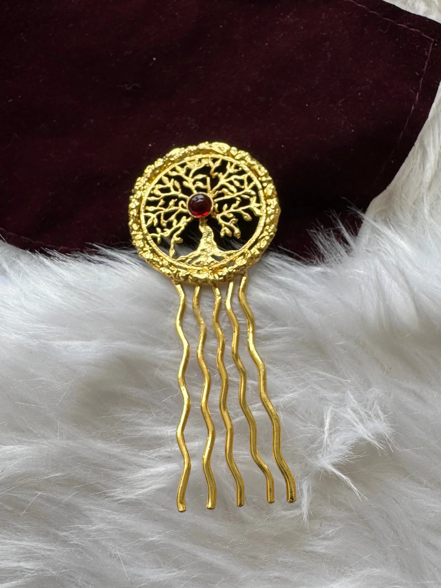 Golden Tree hair pin with intricate tree of life design, red stone center, and wavy gold prongs on white fur by Bows and
