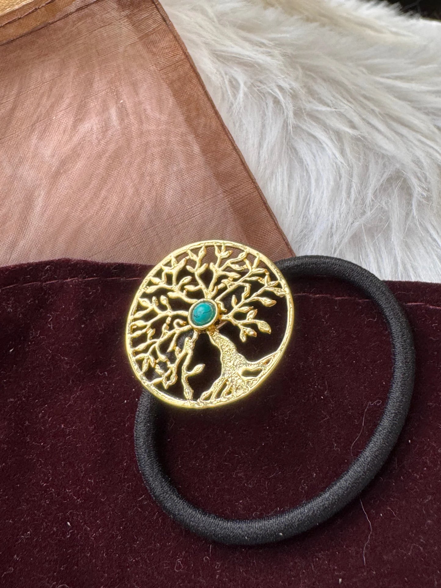 Golden Tree metal hair rubber band with turquoise stone detail by Bows and Bags India, flat lay on burgundy fabric