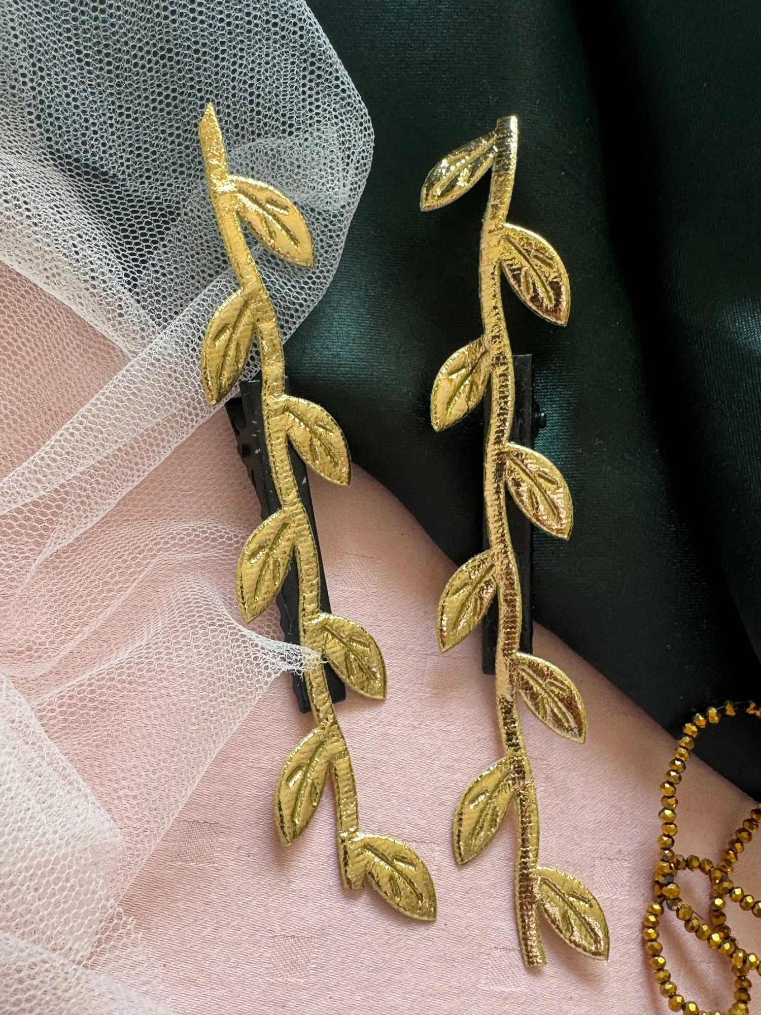 Golden Twig handmade hair clip pair in gold leaf design on pink and green fabric by Bows and Bags India