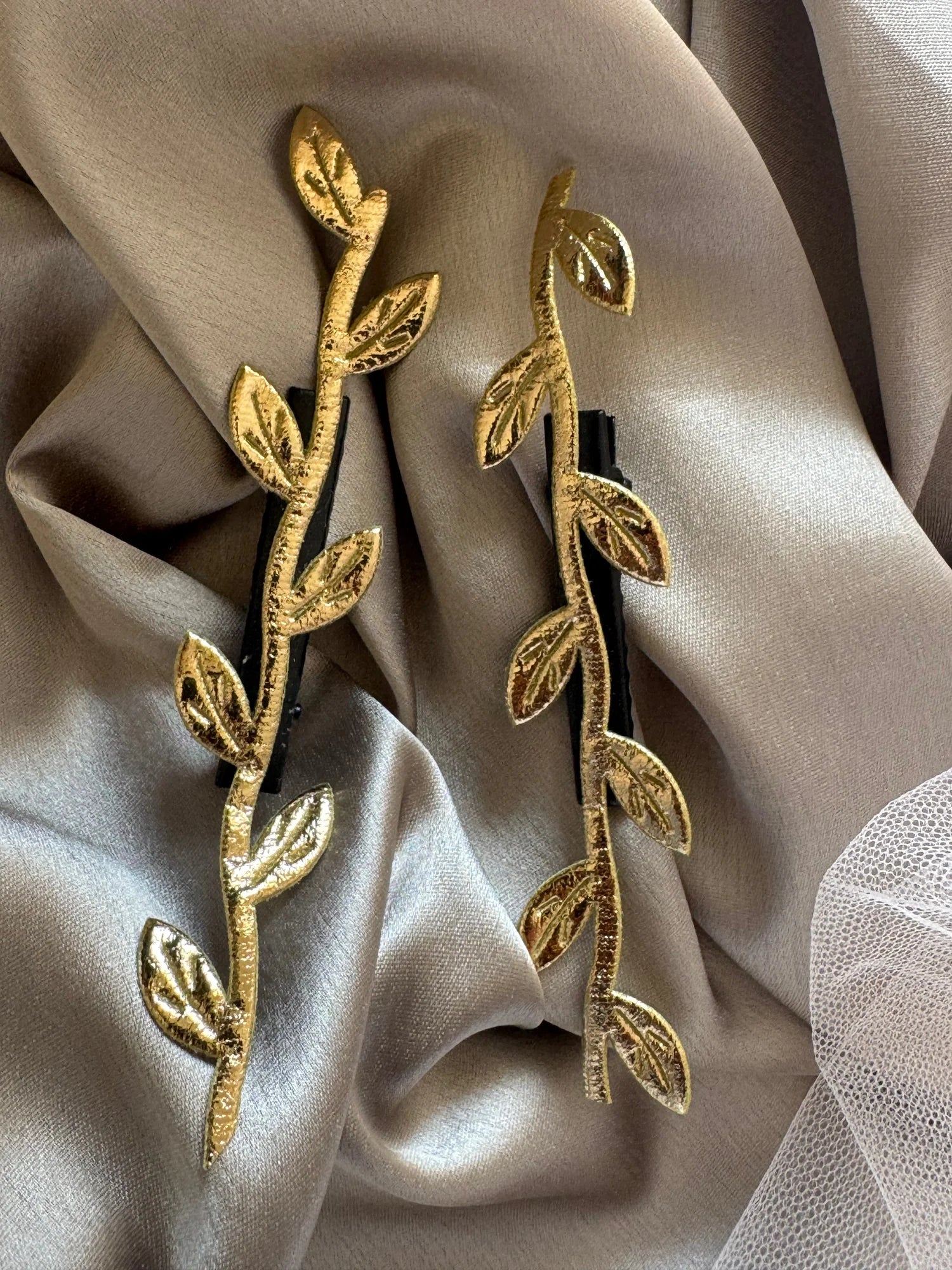 Golden Twig hair clip pair by Bows and Bags India with delicate gold leaf details on neutral fabric background