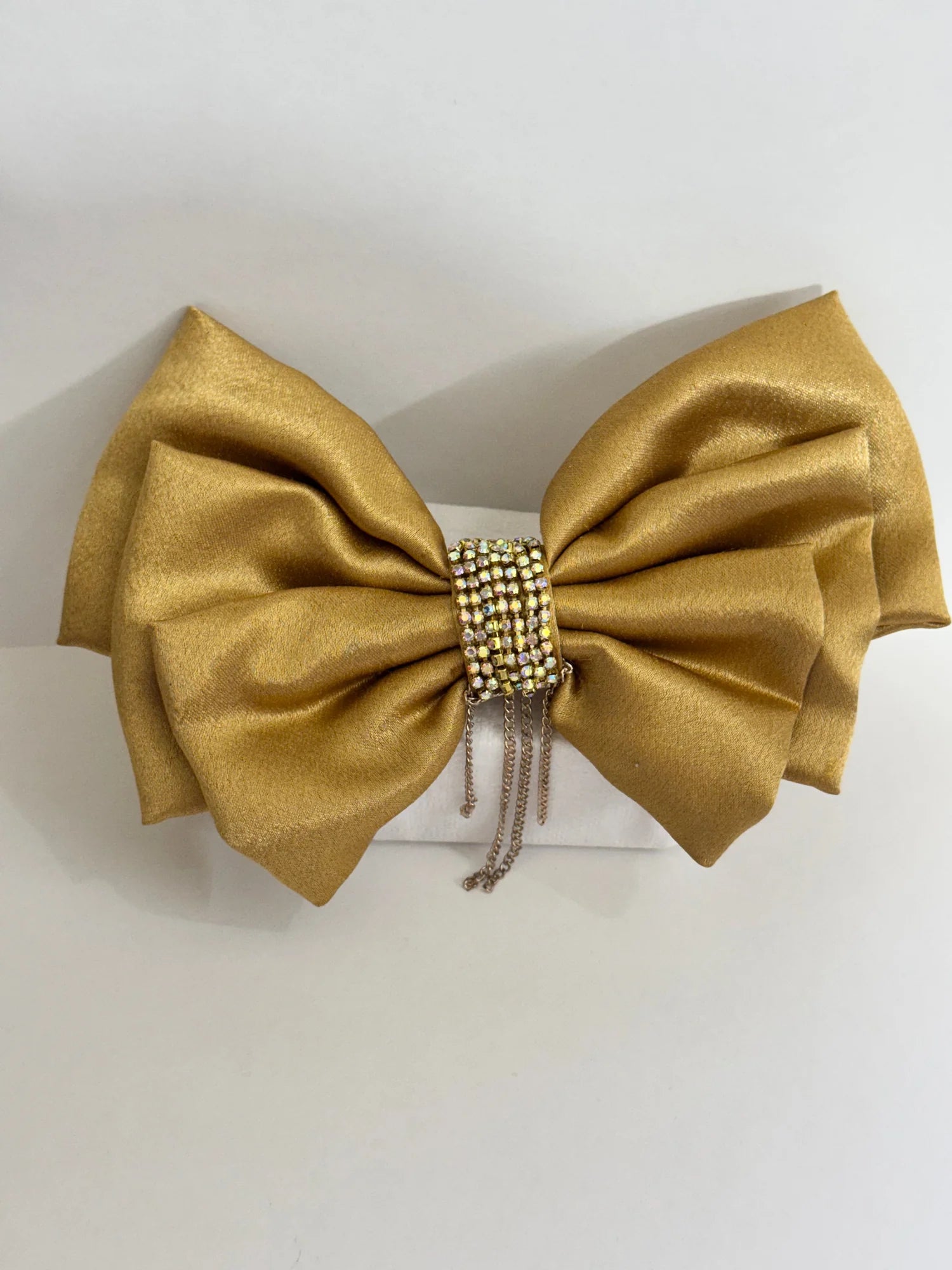 Goldy Bling golden satin hair bow with stone and chain embellishments, flat lay detail shot by Bows and Bags India