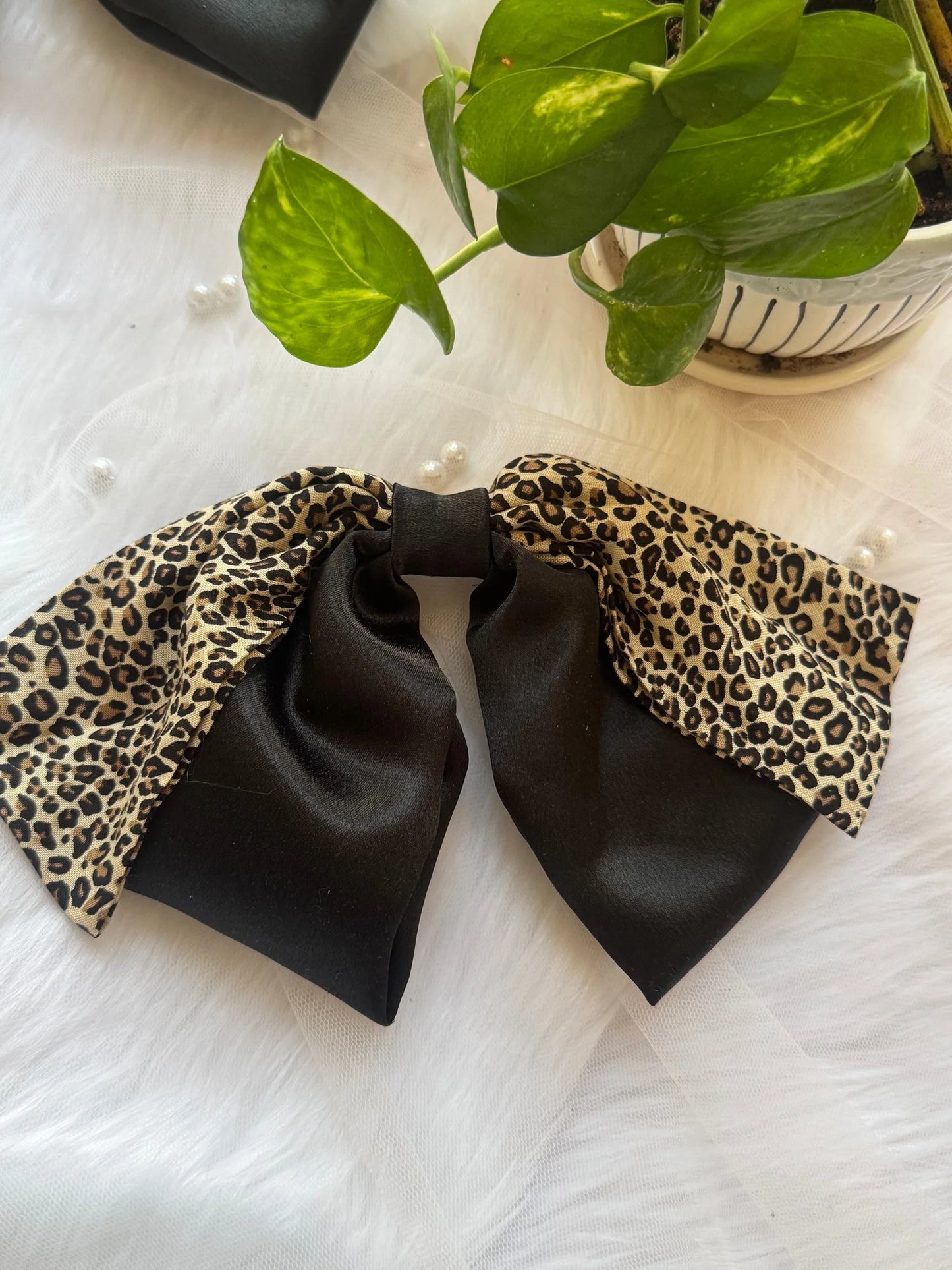 Kate Moss hair bow with black satin and leopard print design by Bows and Bags India handmade accessory flat lay