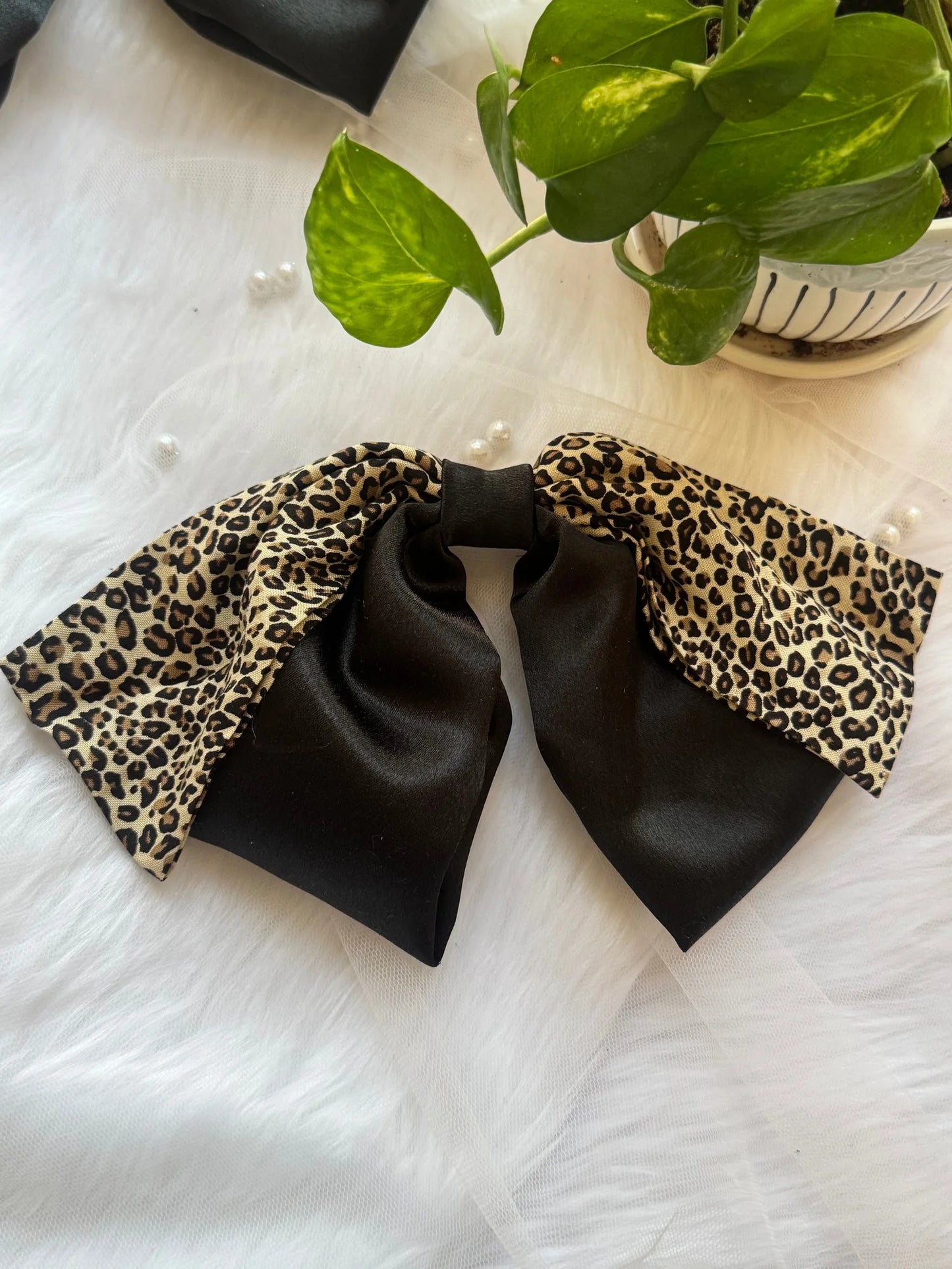 Kate Moss handmade hair bow with black satin and leopard print detail by Bows and Bags India, flat lay styling shot
